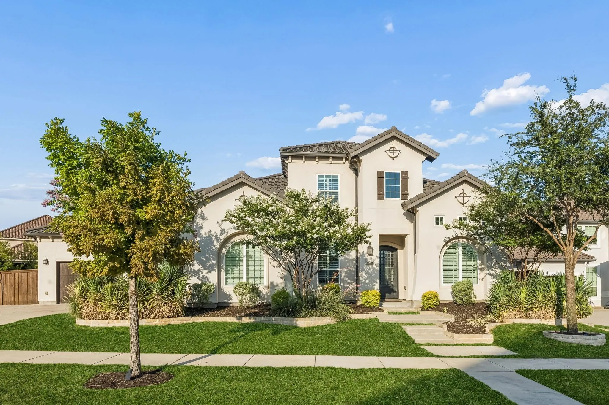 Elegant stucco exterior with a classic tile roof creates a stunning first impression.