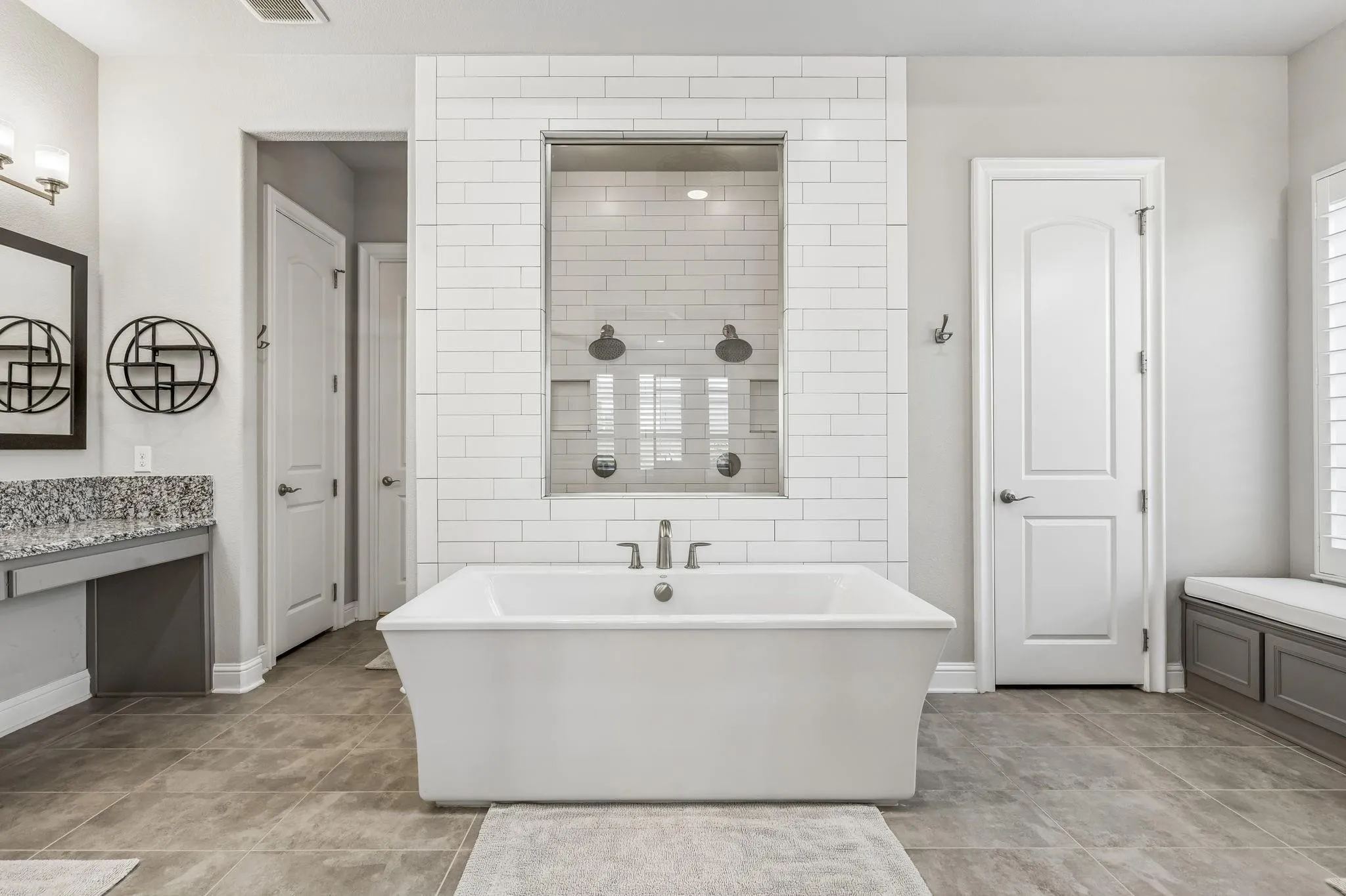 Luxurious primary retreat featuring a spa-inspired bath with a soaking tub and oversized dual-head shower.