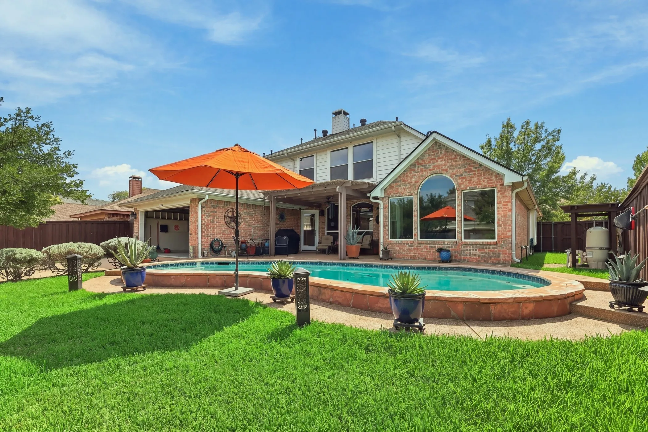 Backyard oasis with covered patio and salt water pool and yard to play.