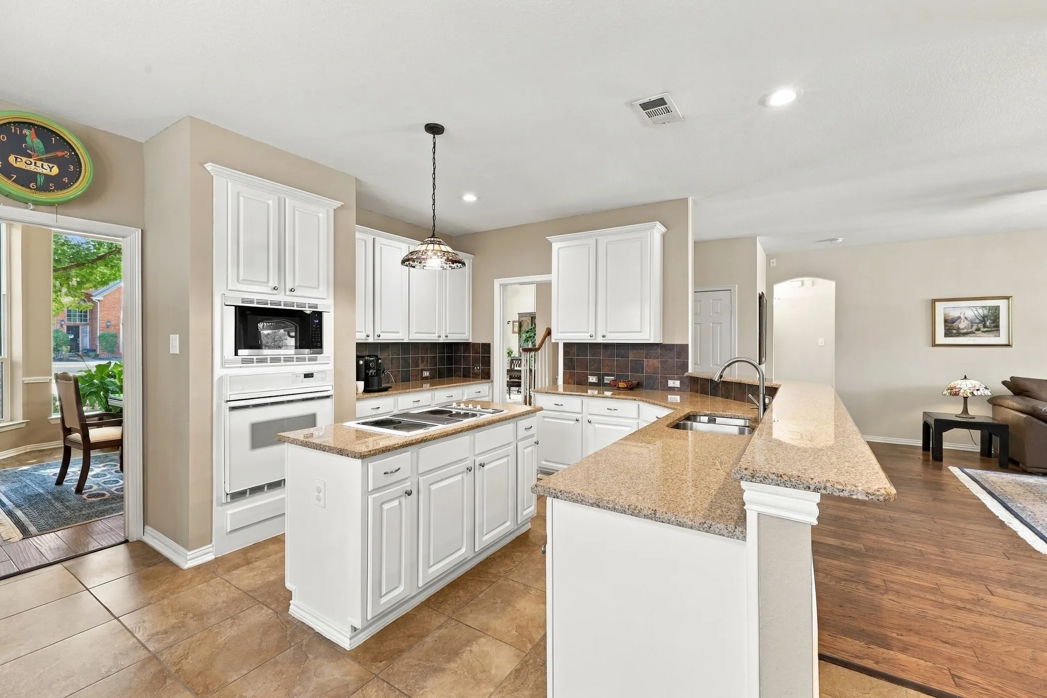 Large island kitchen with granite counters, painted cabinets, and breakfast bar.