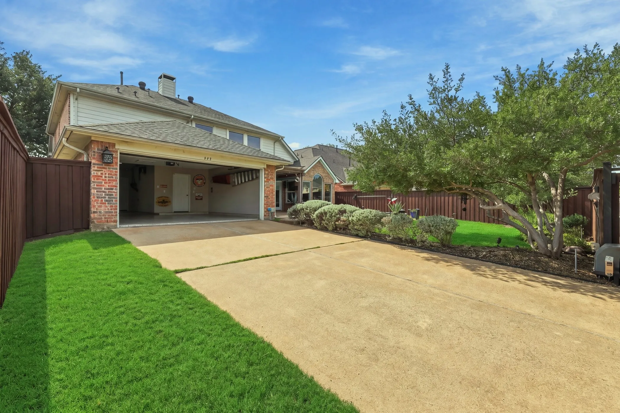 Garage and driveway enclosed with electric driveway gate.