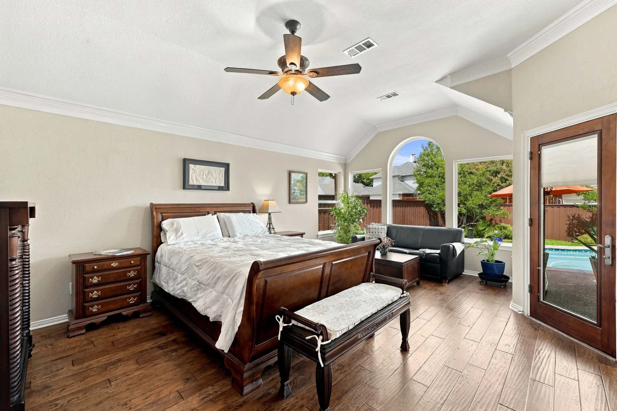 Primary bedroom with sitting area and door to backyard patio and pool.