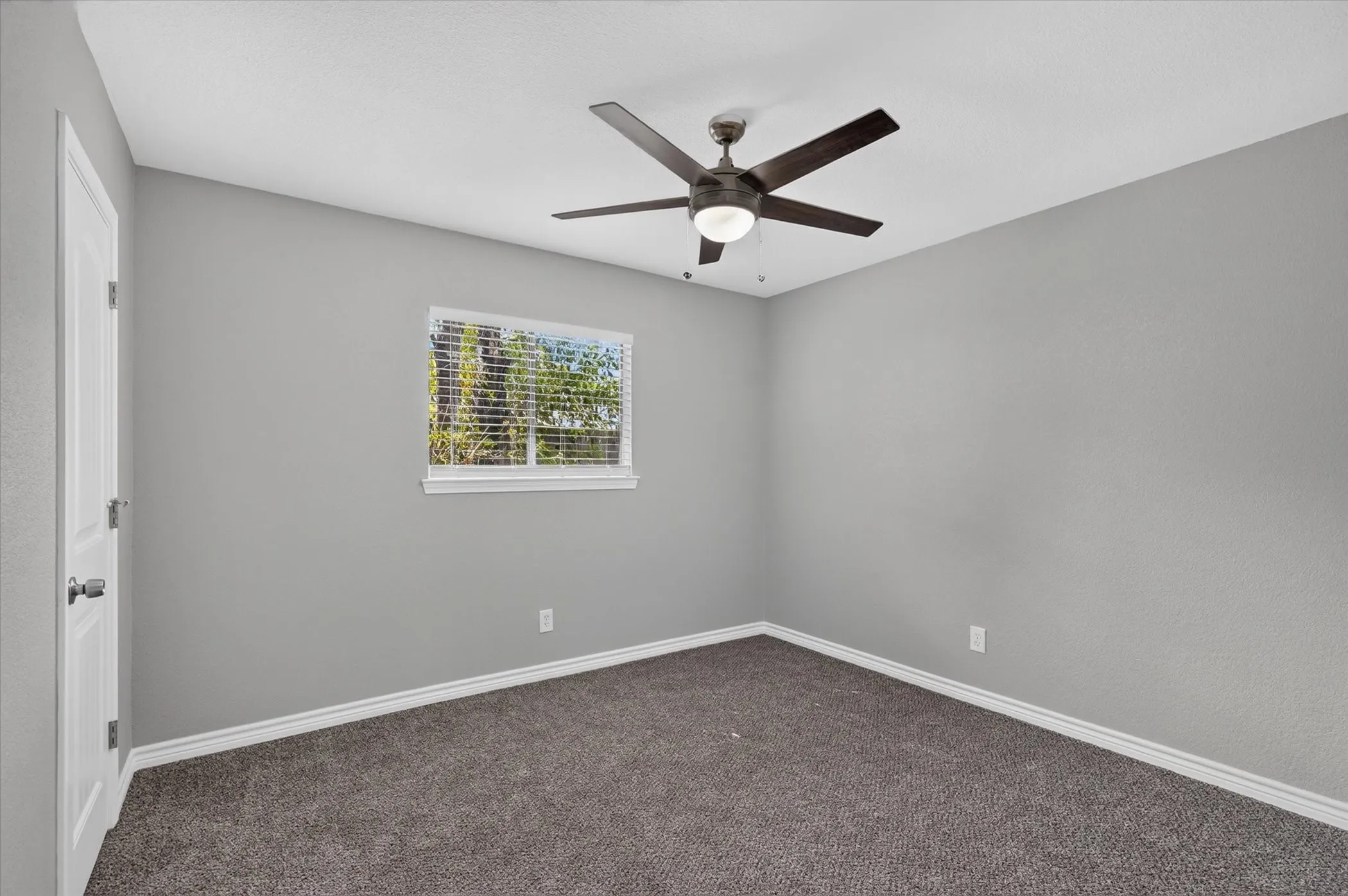 Neutral wall paint, ceiling fan, carpet flooring, window with blinds, and white trim