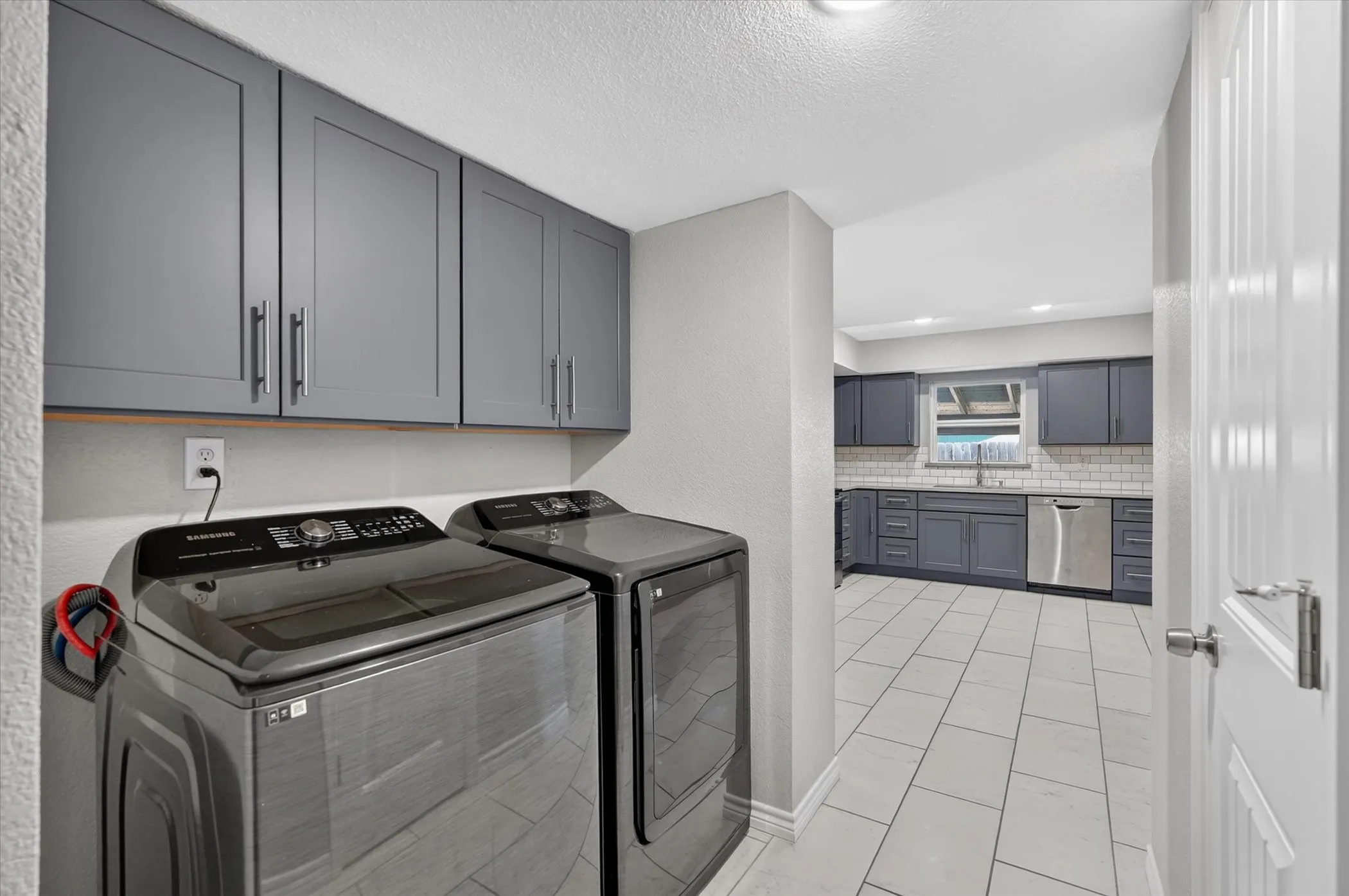 Laundry area with integrated upper cabinetry