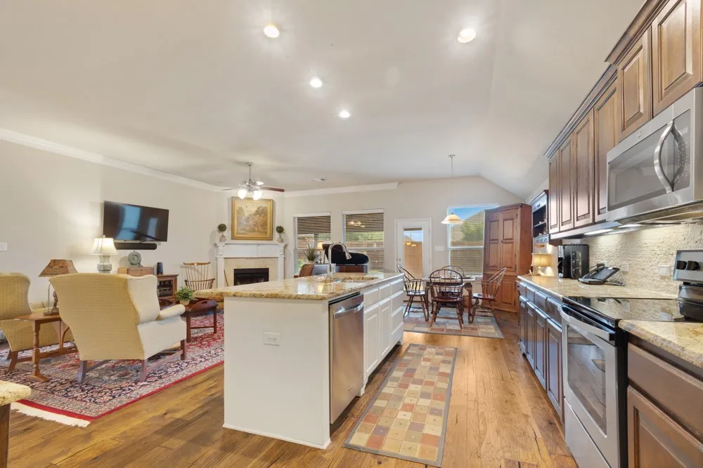 Kitchen island with breakfast bar open to living area. Custom Alder cabinets and granite countertops.