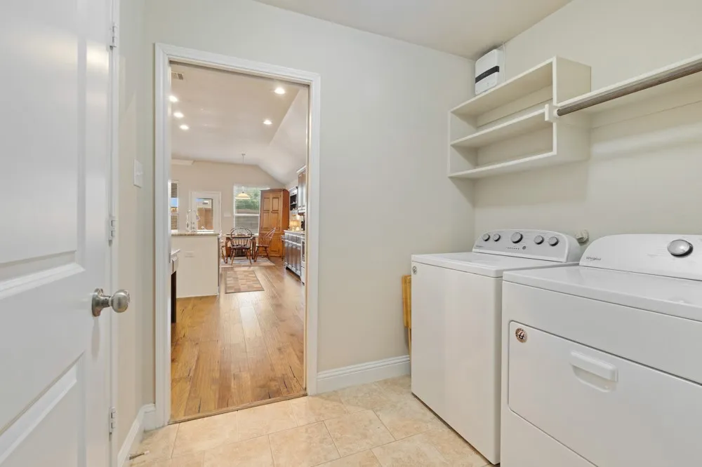 The utility room offers shelving for storage, a hanging bar and a pantry with double doors for ease of access.