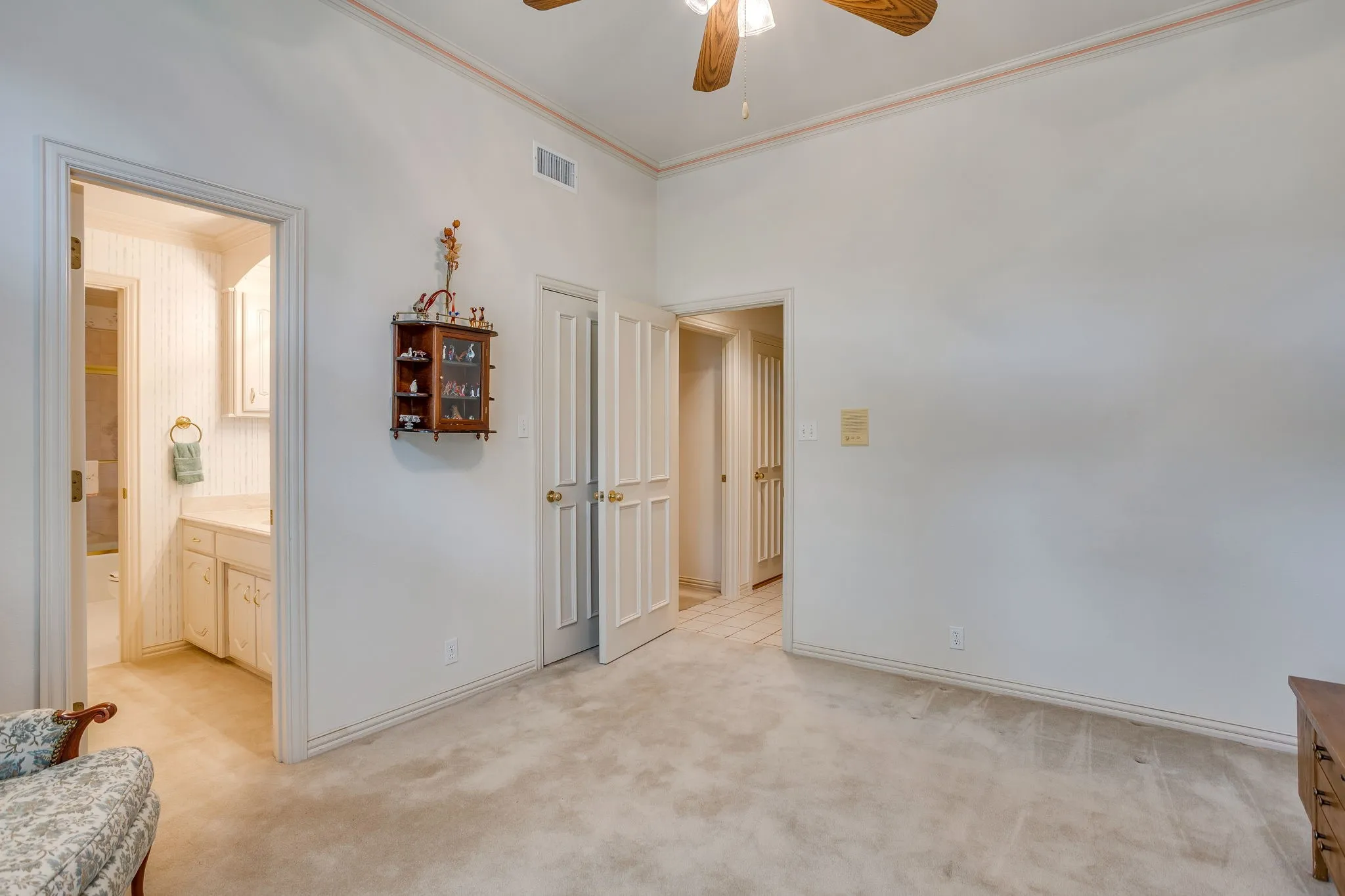 Carpeted flooring, white walls, and a ceiling fan with integrated lighting
