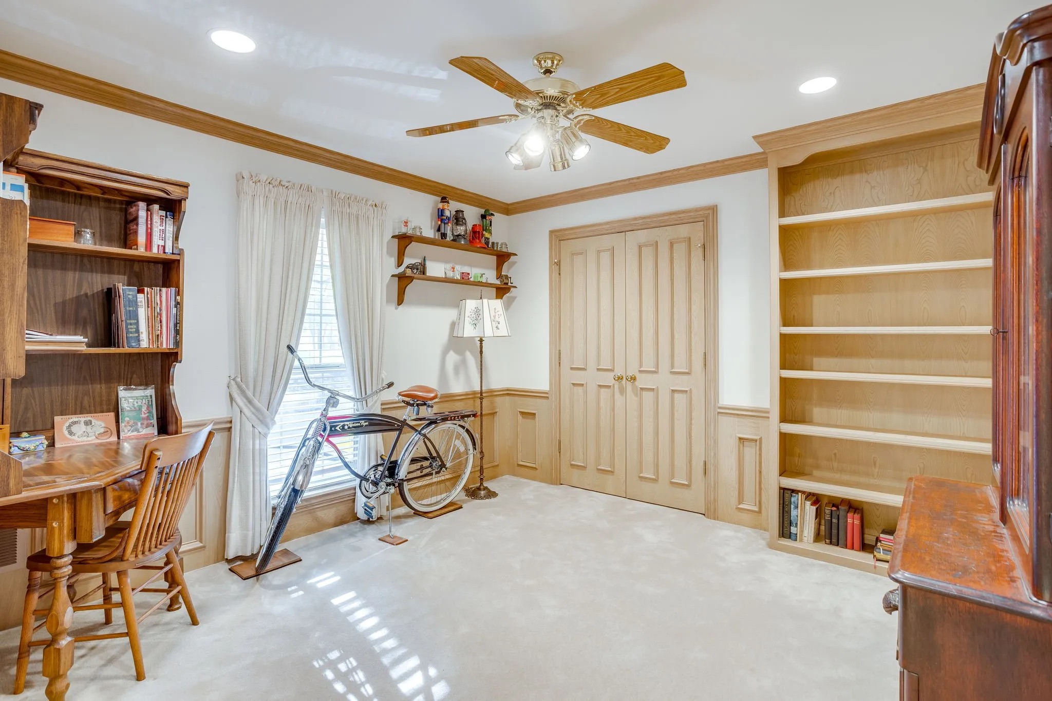 Recessed lighting, wood trim, wood paneled double doors, built-in shelving, and carpeting
