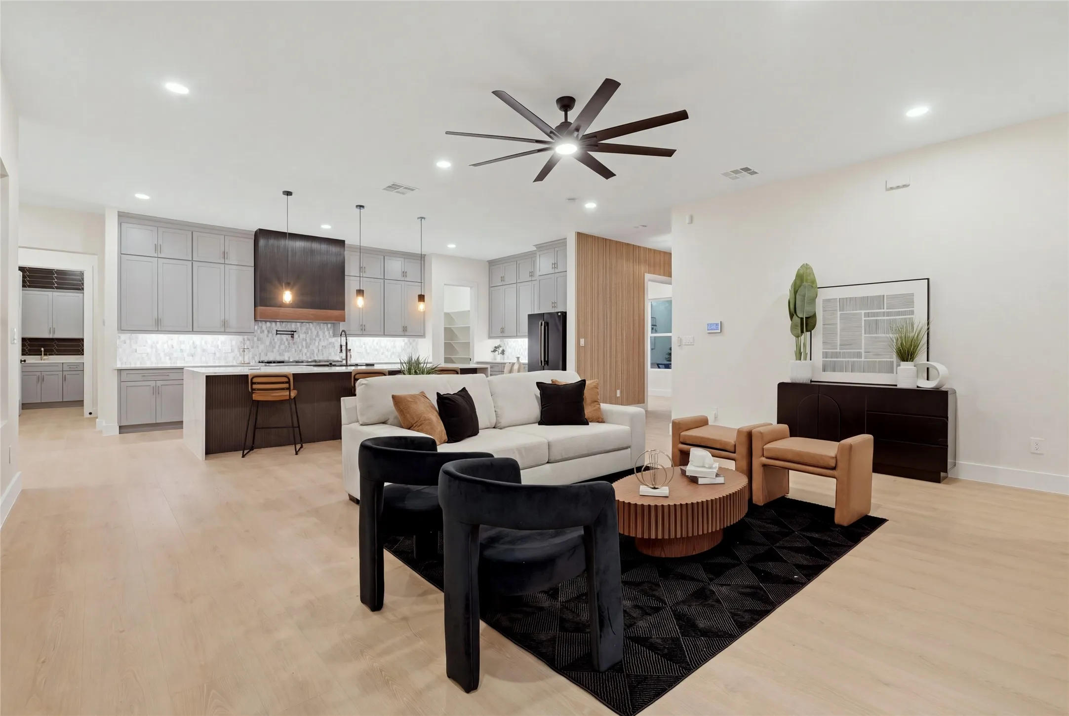 Open-concept living area featuring light wood-finish flooring, a contemporary ceiling fan, and recessed lighting