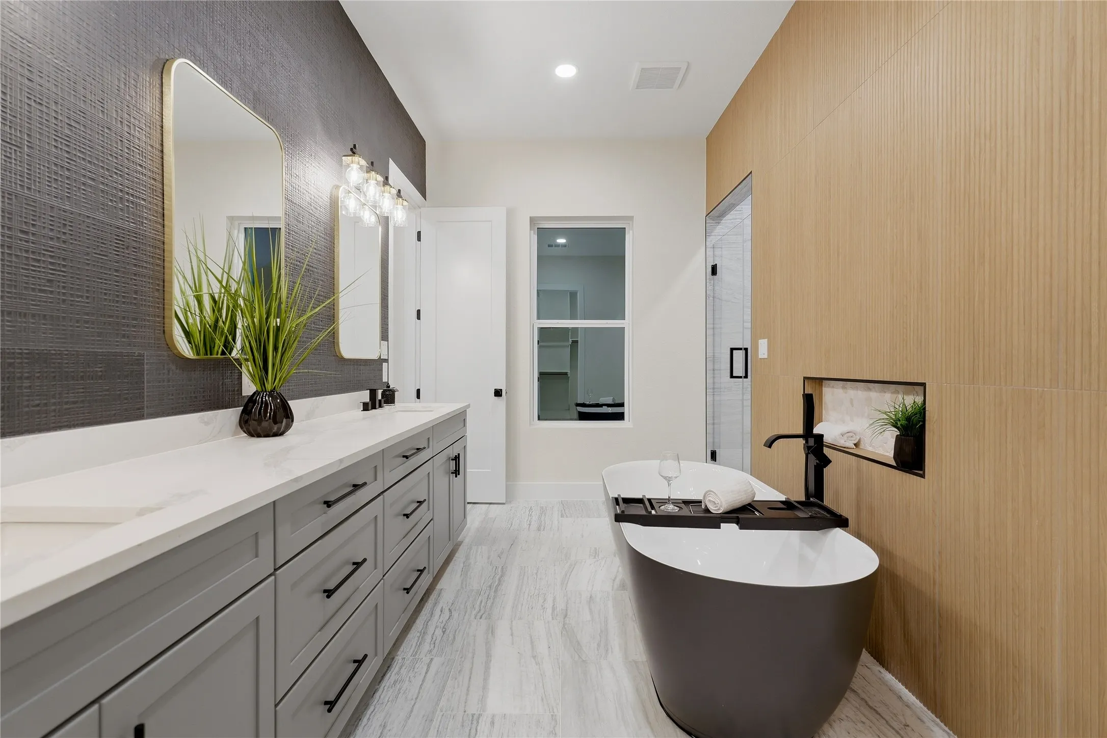 Dual vanity with white countertops, modern rectangular mirrors, and stylish wall sconces