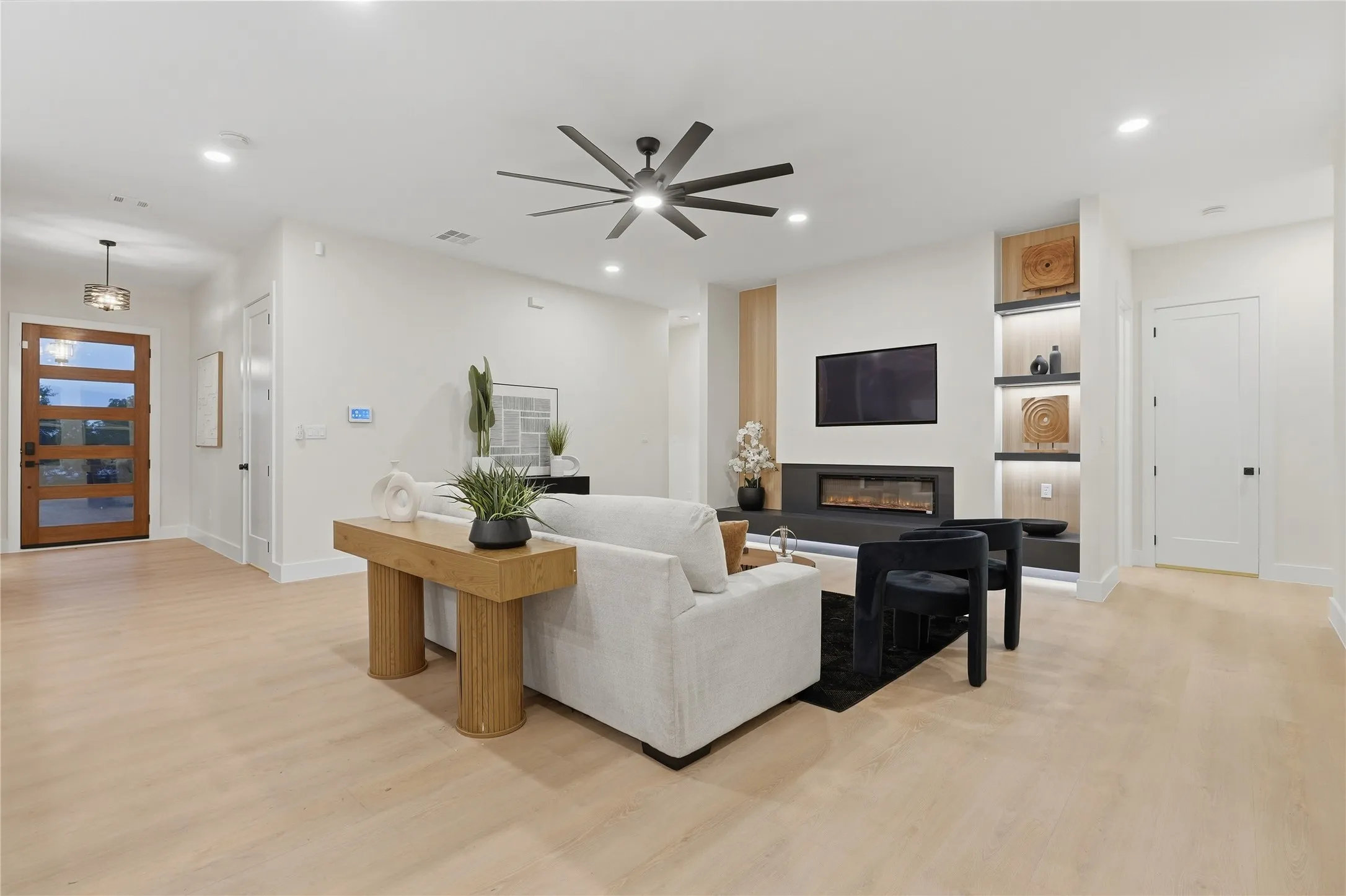 Wide plank wood-finish flooring, recessed lighting, and a contemporary ceiling fan