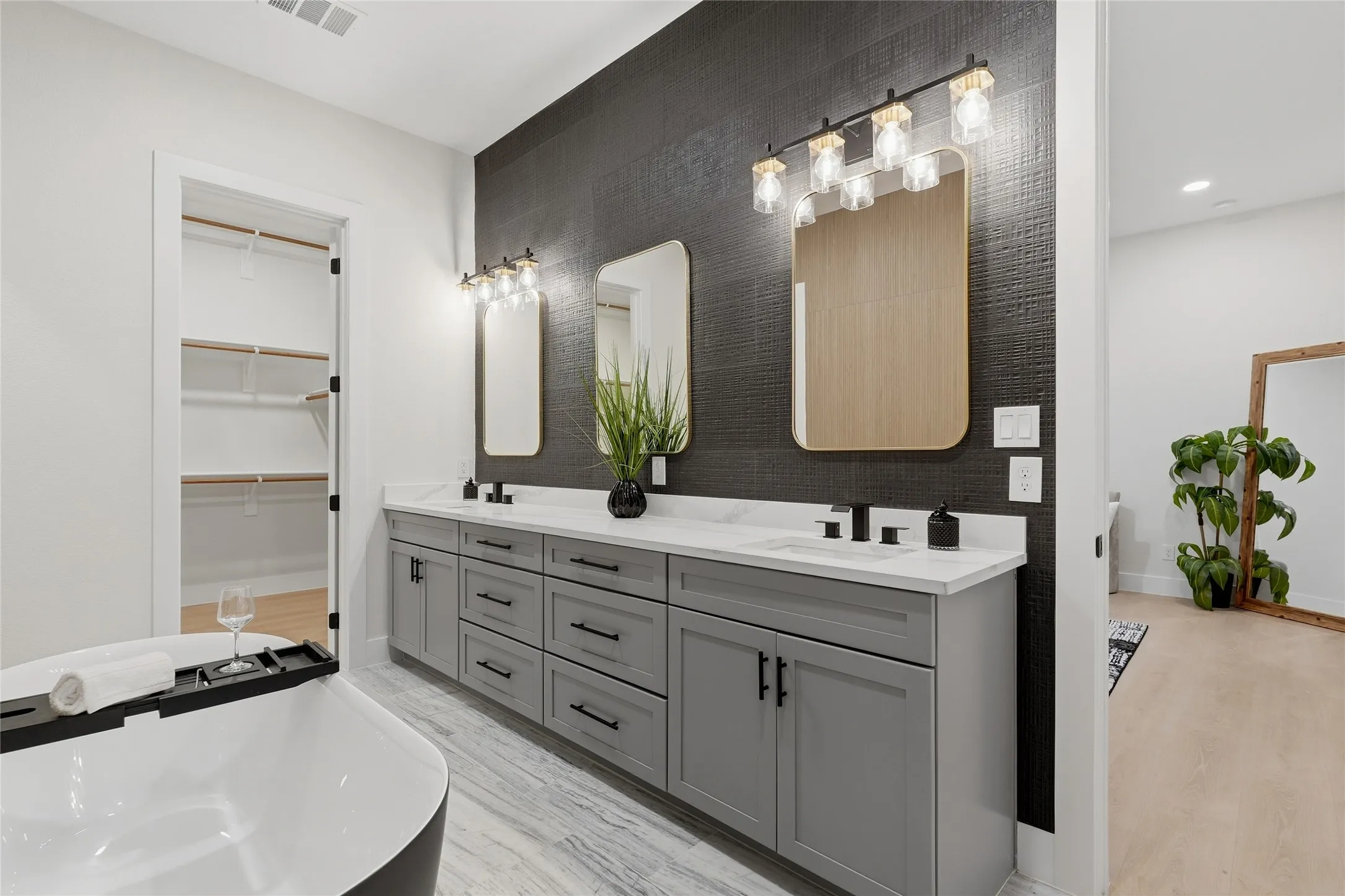 Dual vanity with white countertops, matte black faucets, and gray cabinetry
