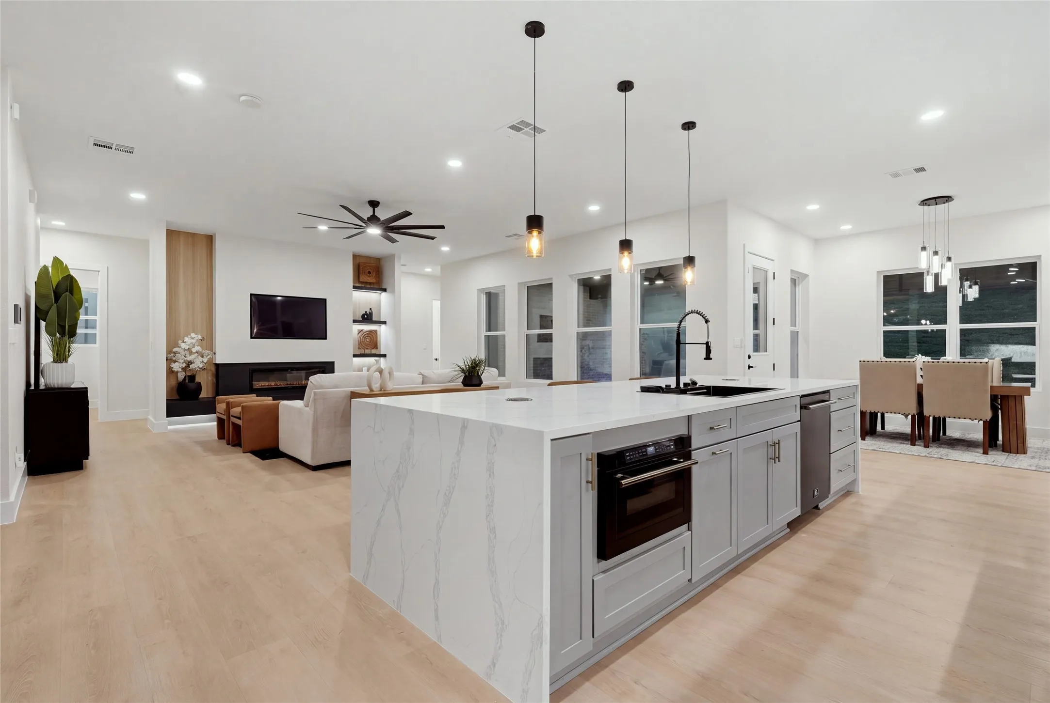 Spacious kitchen island with a waterfall countertop, integrated microwave, and pendant lighting
