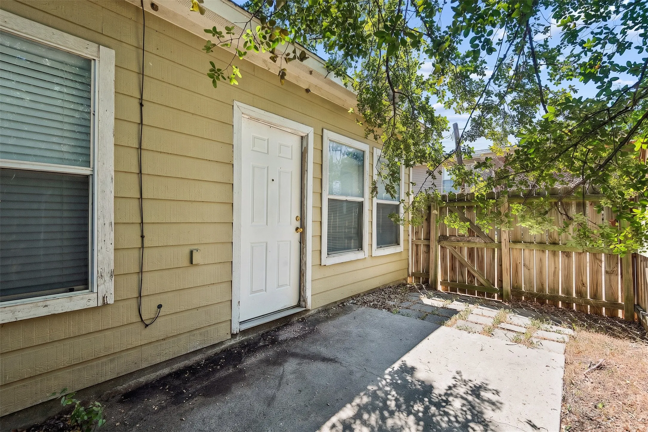 Rear exterior view highlights the siding finish, mature trees and fenced yard that provide dedicated outdoor space for the residence. | 5933 Robinwood