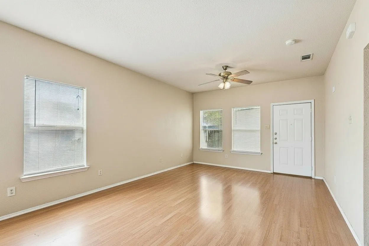 Light-filled living room with durable wood-look laminate flooring and neutral finishes creates an easy-care, versatile living space. | 5931 Robinwood