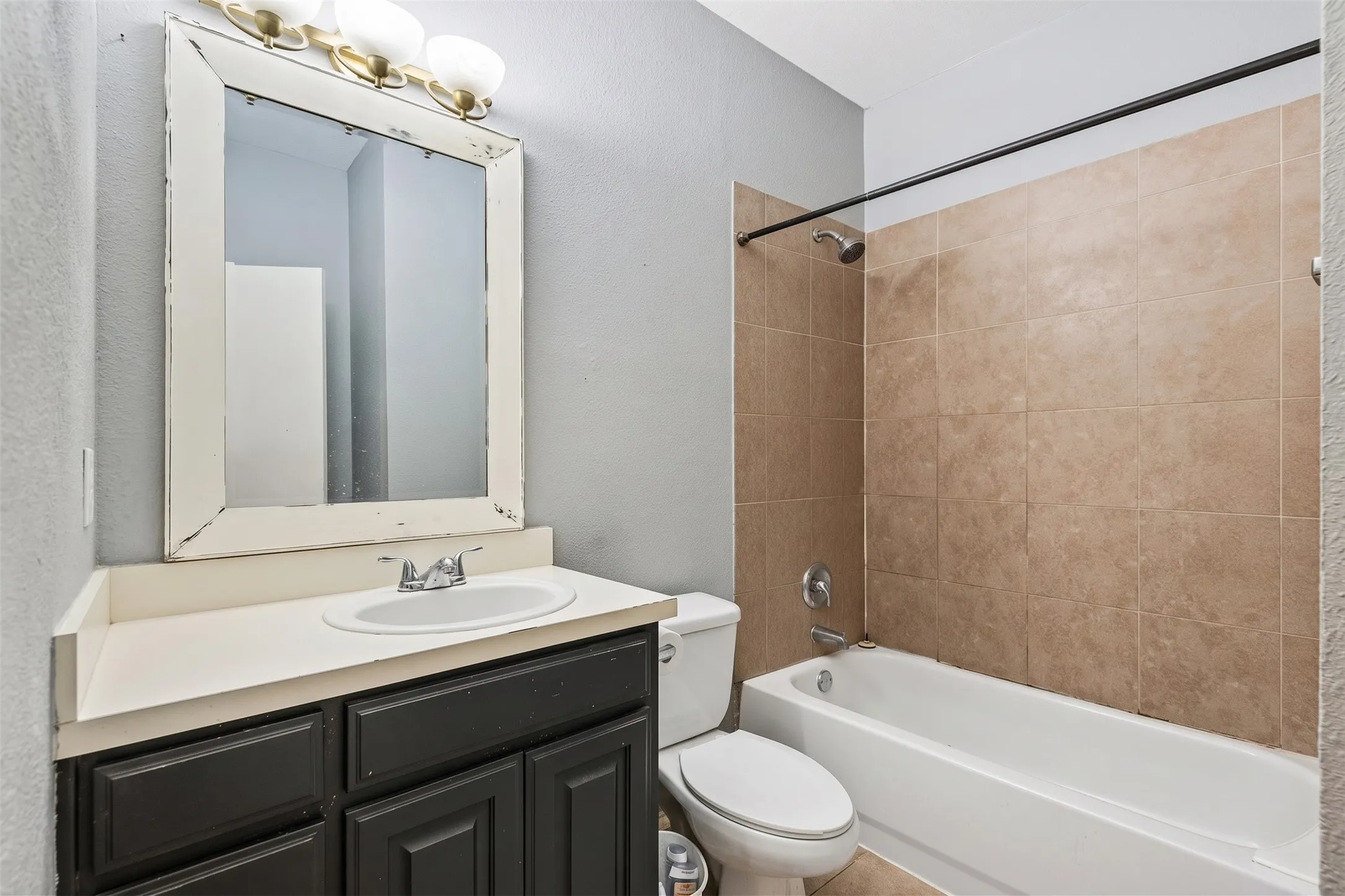 Full bathroom offers a laminate vanity countertop, storage and a tub and shower combination in a practical layout. | 5933 Robinwood