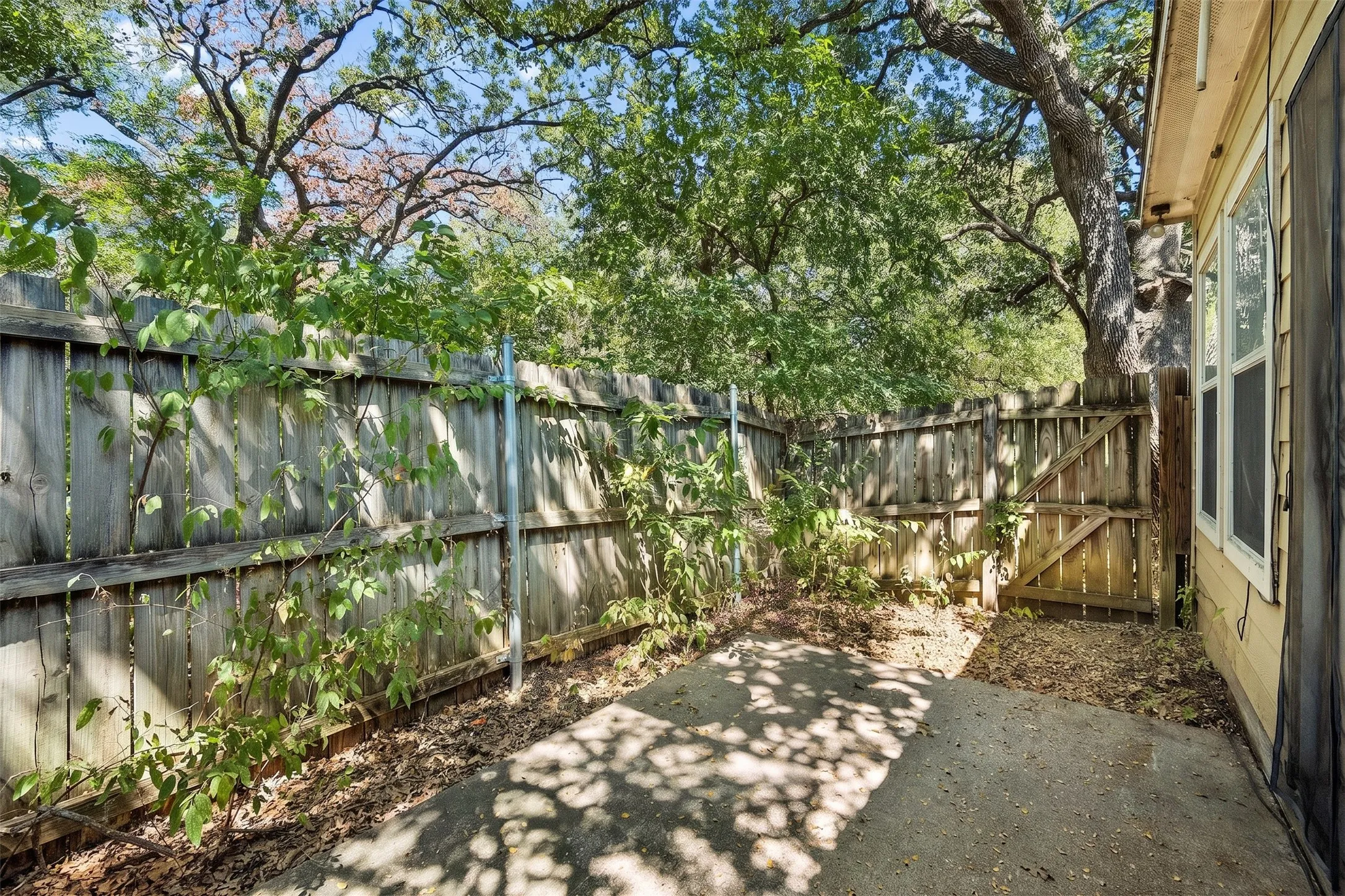 Fenced outdoor space beneath mature trees provides welcome shade and a private area for outdoor enjoyment. | 5933 Robinwood