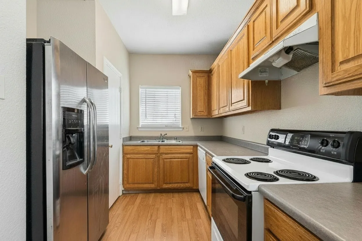 Functional kitchen features stained cabinetry, laminate countertops and an electric range with convenient access to the adjoining dining area. | 5931 Robinwood