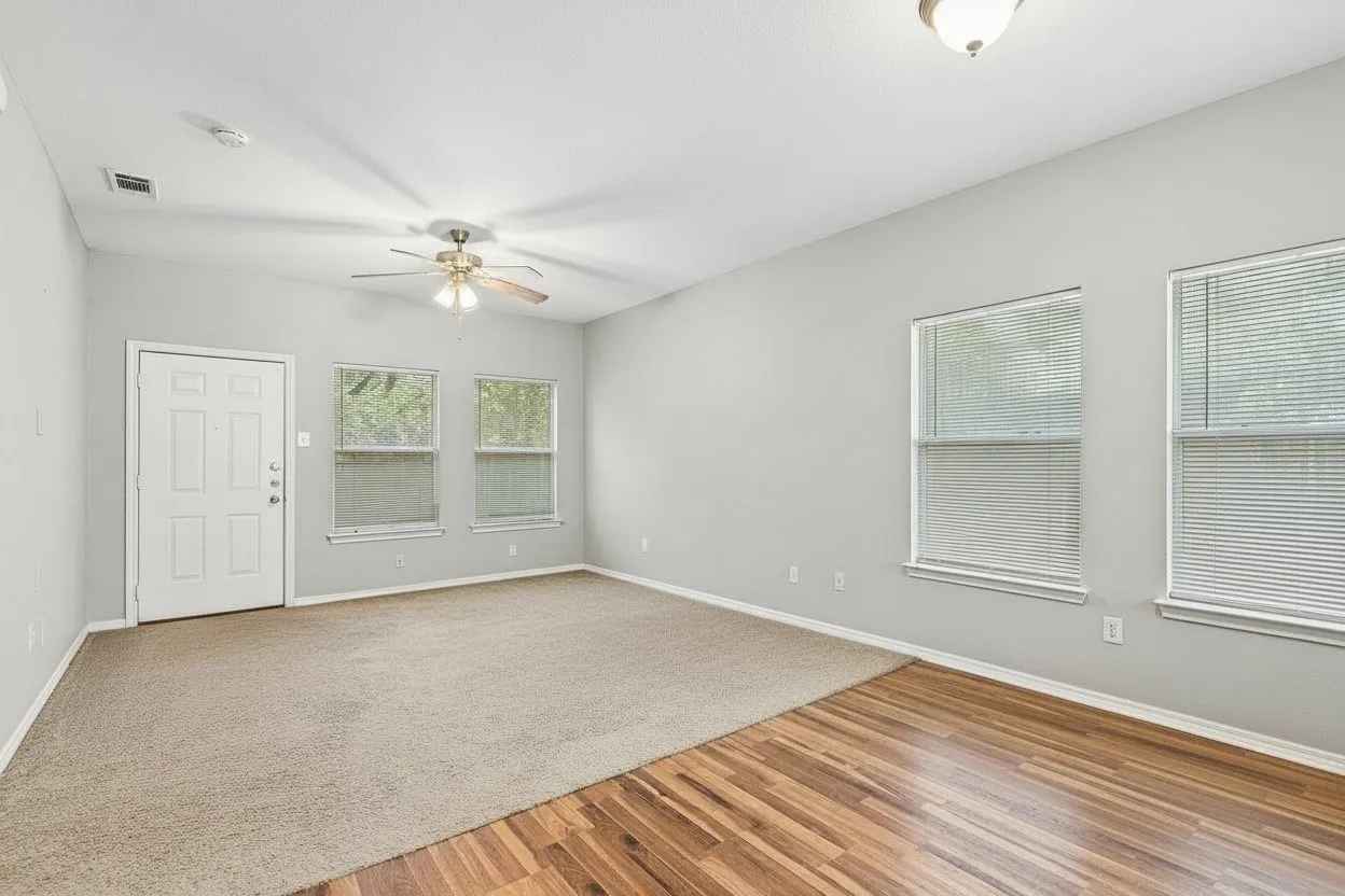 Spacious living room offers comfortable carpet underfoot, neutral interior paint and multiple windows bringing in natural light. | 5933 Robinwood