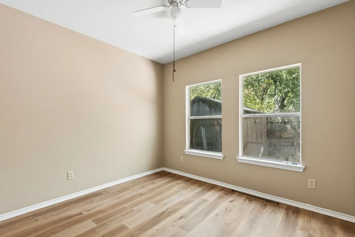 The second bedroom also features neutral paint, wood-like flooring ceiling fan and closet. | 5961 Robinwood