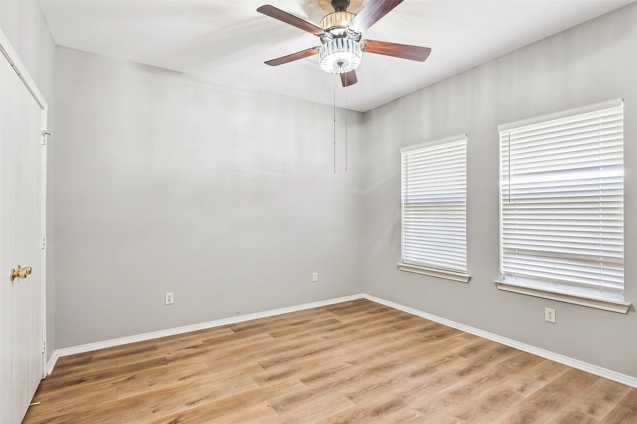 Wood-like laminate flooring in bedroom offers a comfortable retreat with neutral finishes and multiple windows providing abundant natural light. | 5959 Robinwood