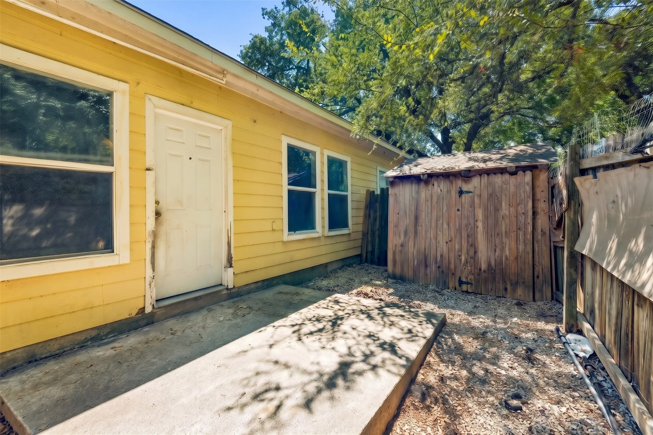 Rear exterior view highlights the siding finish, mature trees and fenced yard that provide dedicated outdoor space for the residence. | 5961 Robinwood