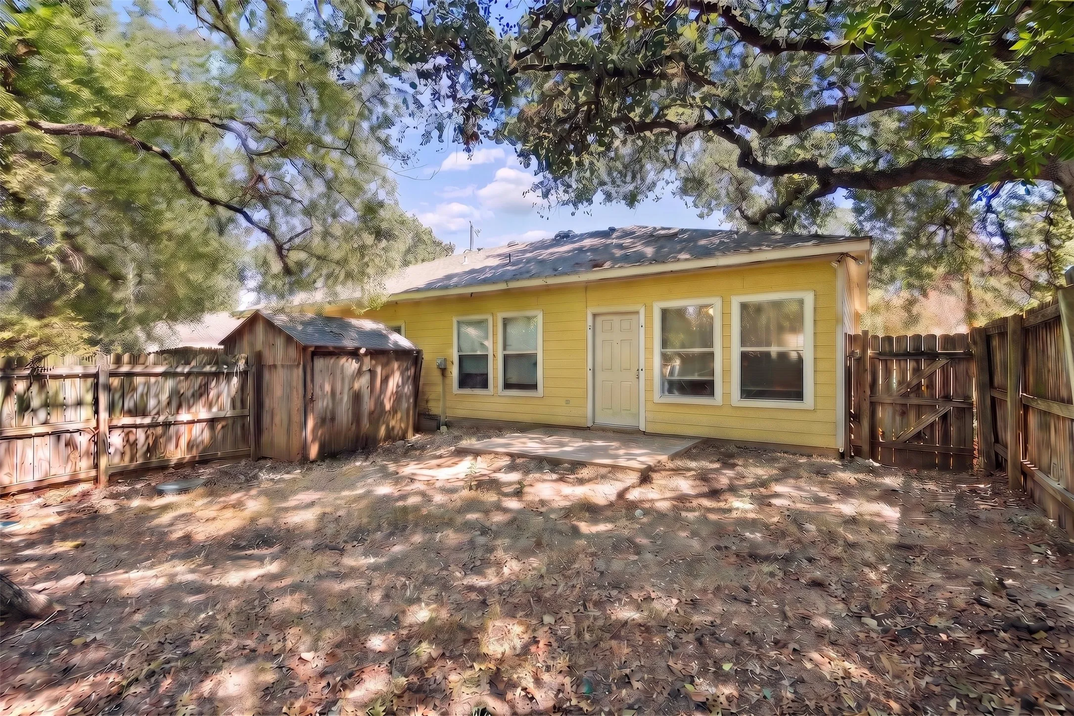Mature trees shade the fenced backyard, creating a pleasant setting to enjoy the extended patio or spend time outdoors. | 5959 Robinwood