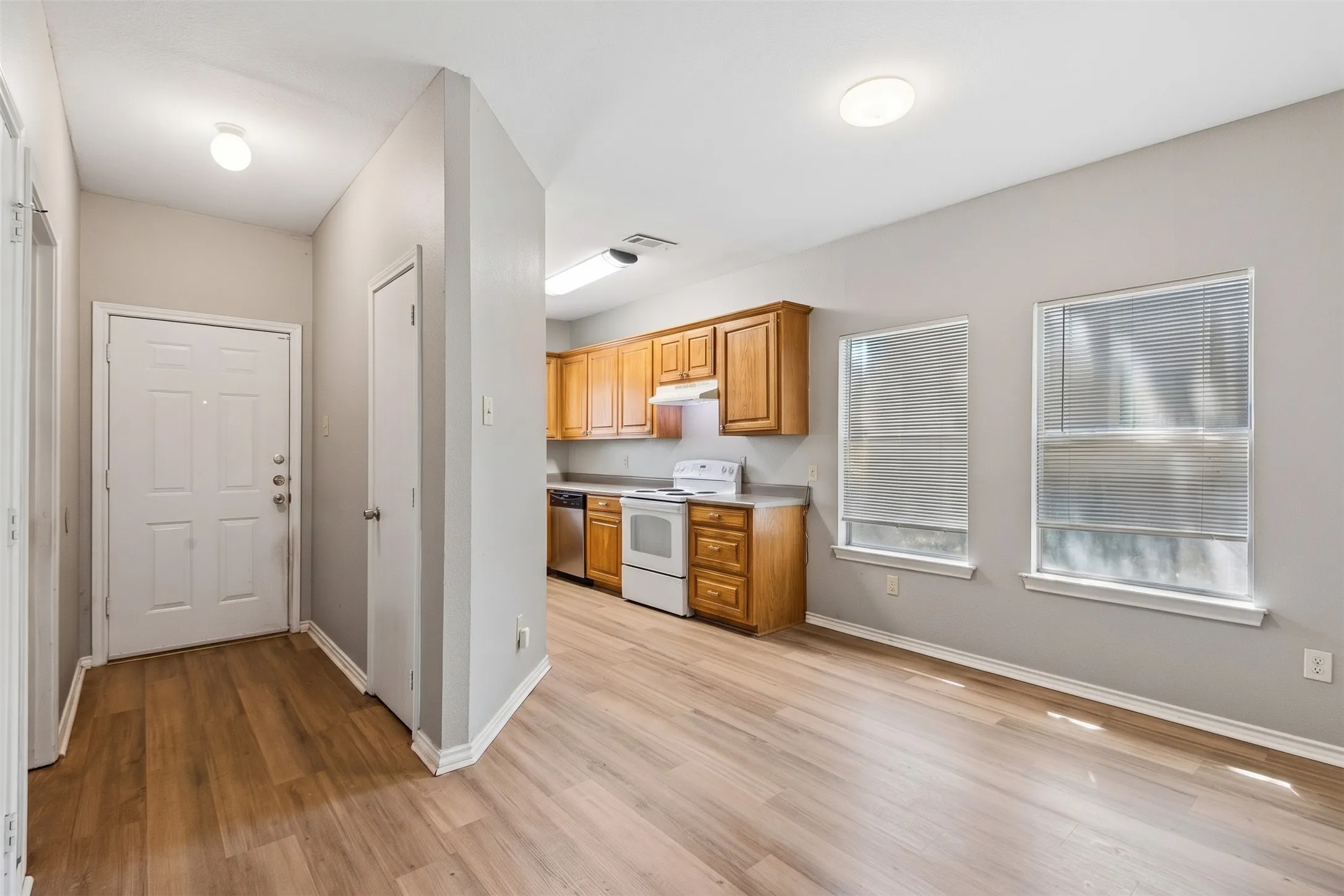 Light-filled living room with durable wood-look laminate flooring and neutral finishes creates an easy-care, versatile living space. | 5959 Robinwood