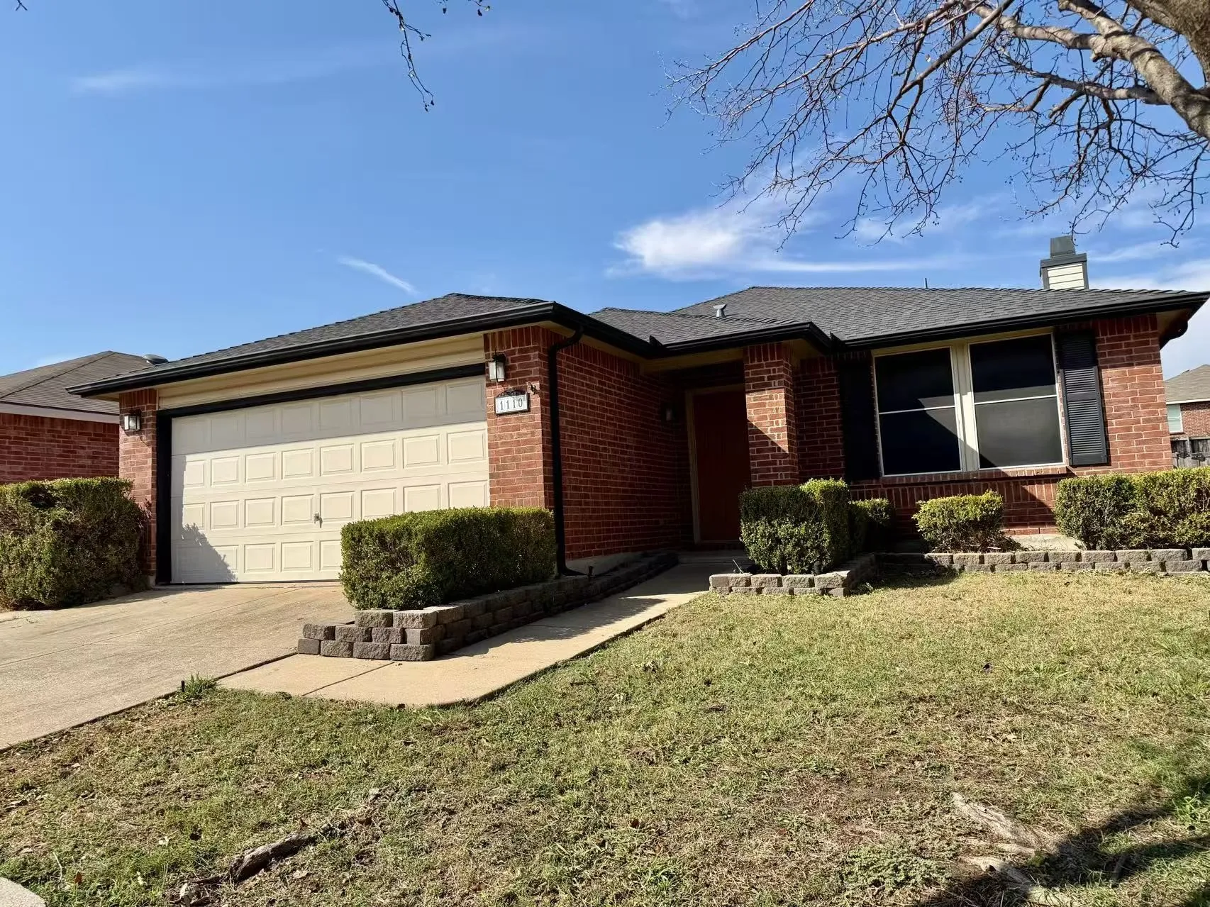 Brick exterior with a dark shingle roof