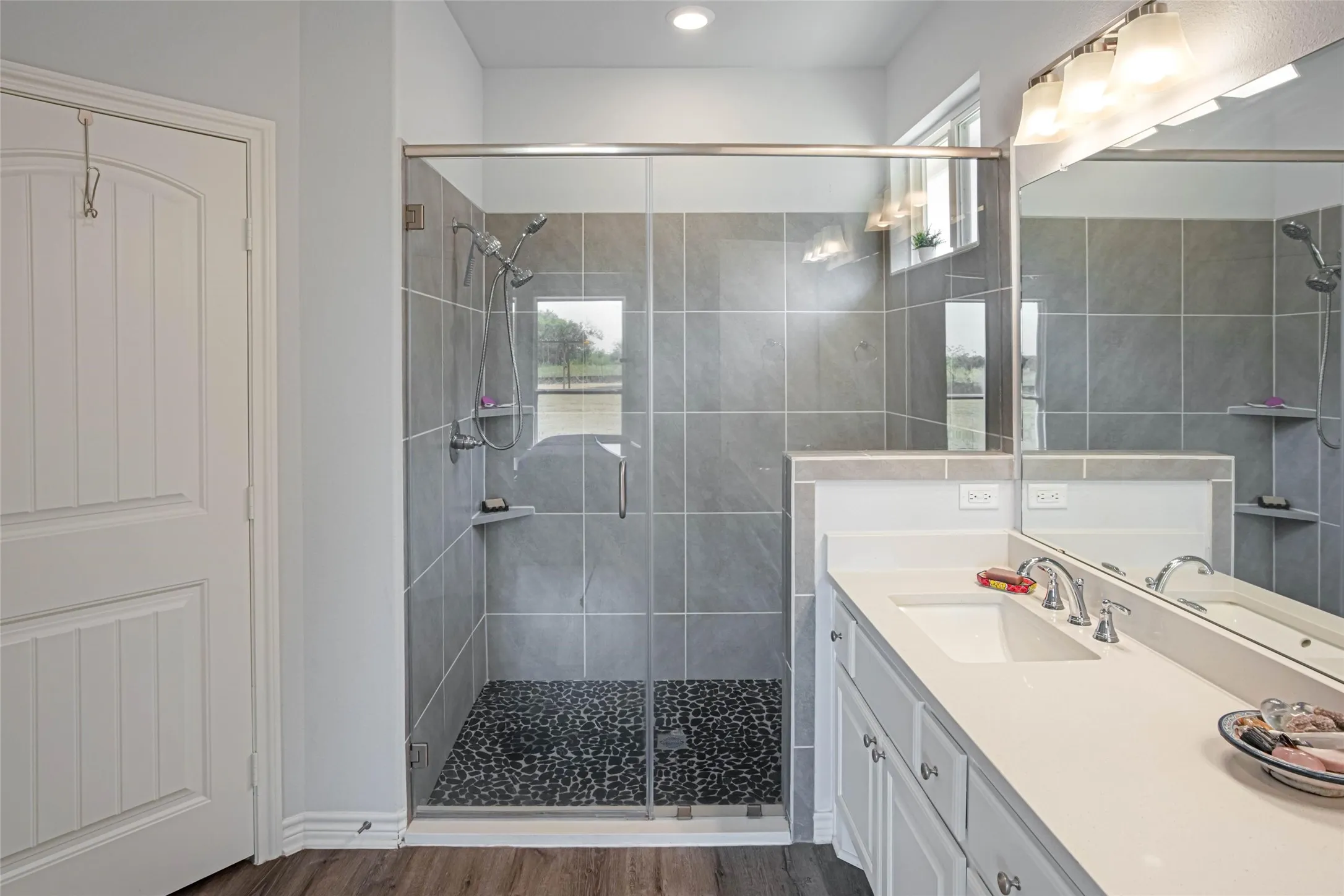 Glass-enclosed shower with a pebble floor and tiled walls