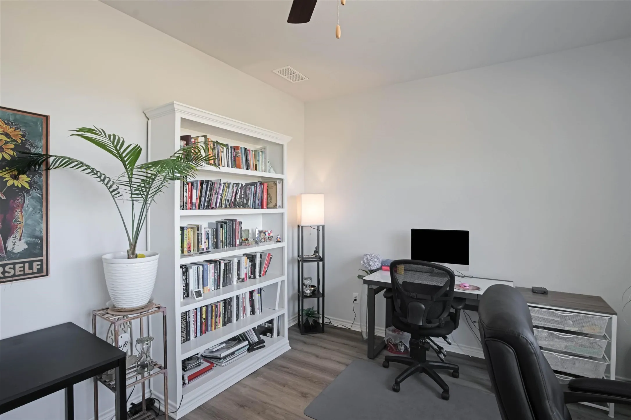 Built-in shelving, wood-finish flooring, and ceiling fan