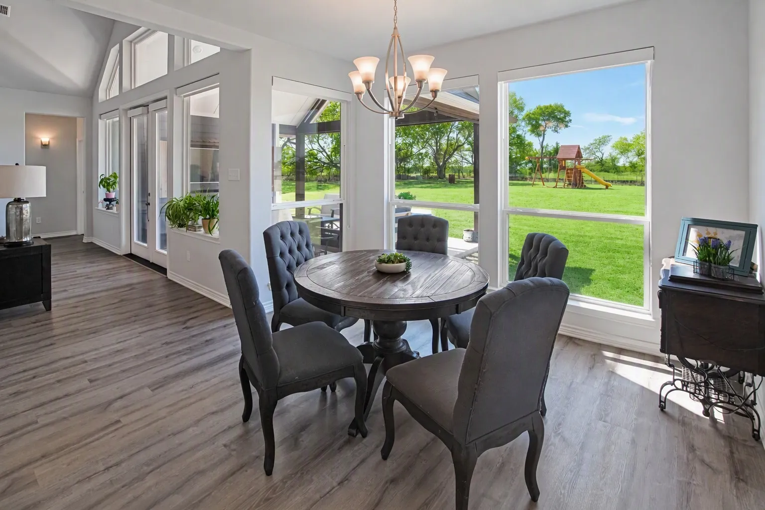 Wood-finish flooring throughout, vaulted ceiling, and expansive windows