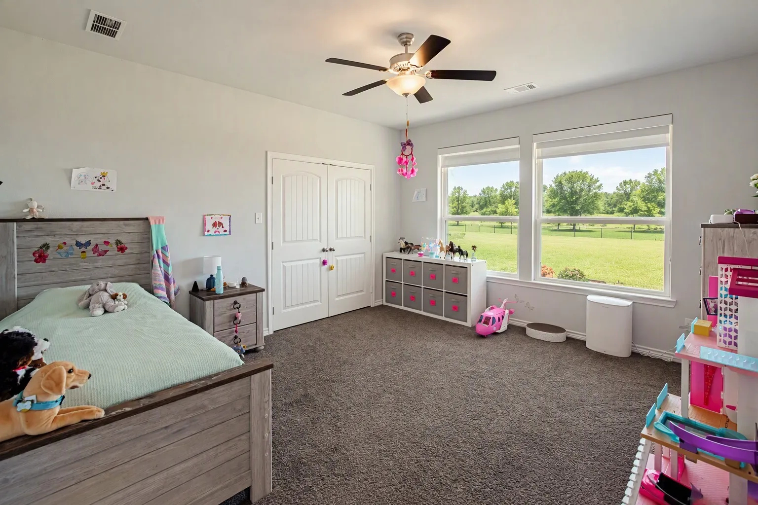 Neutral wall paint, ceiling fan with light fixture, dual windows, and carpet flooring