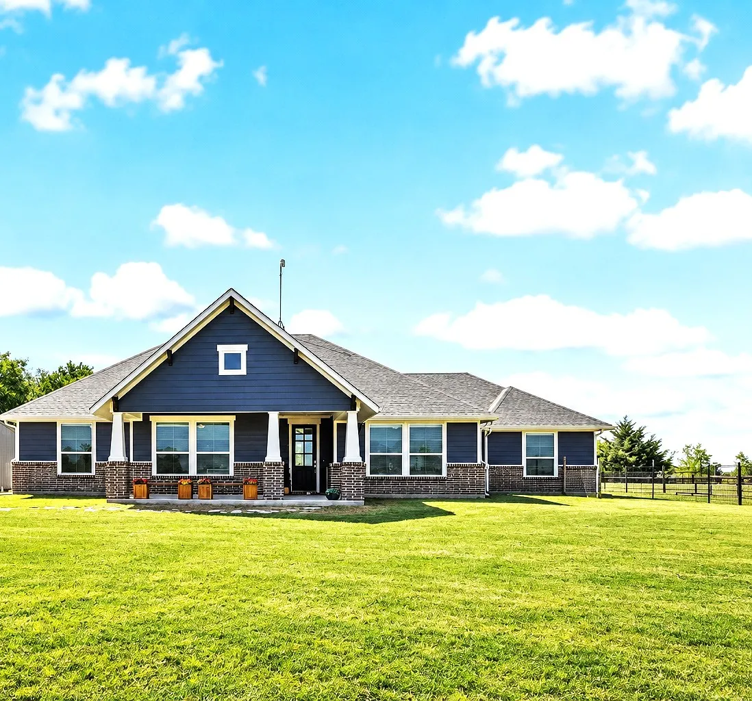 Single-story residence featuring a dark blue siding and brick exterior with white trim