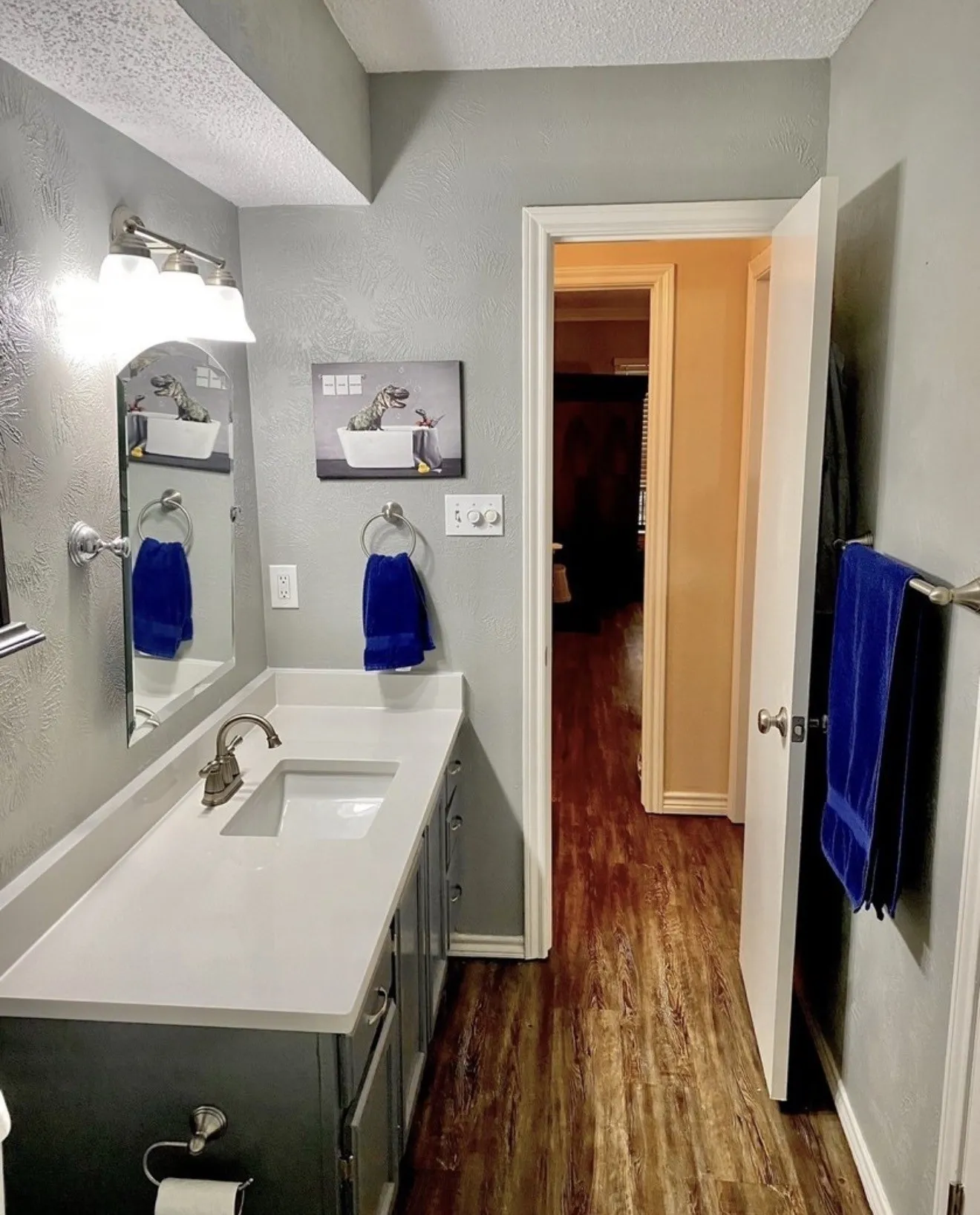 Bathroom vanity with an integrated rectangular sink, brushed nickel faucet, and a large mirror