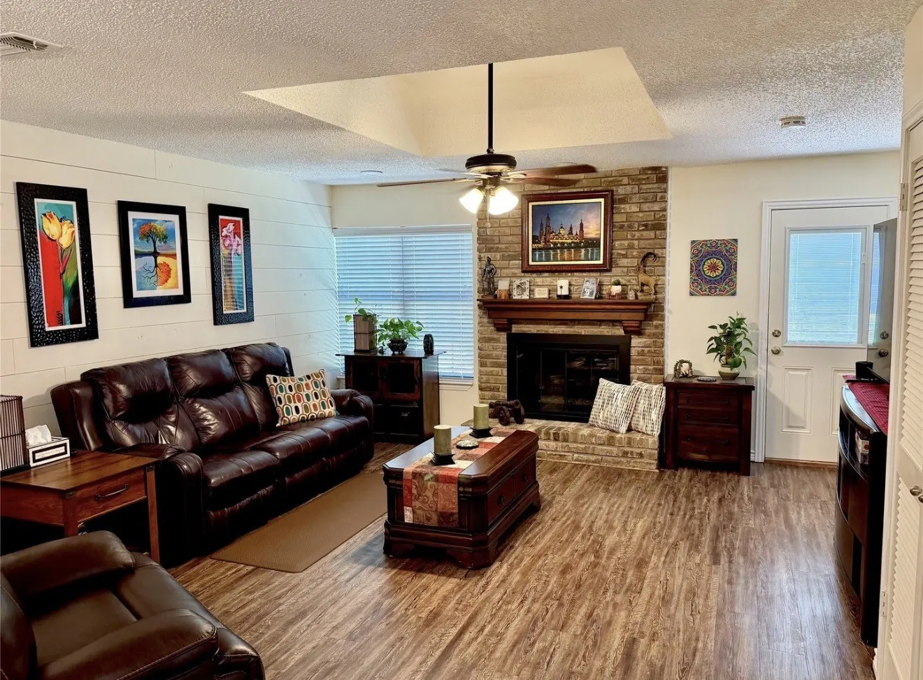 Brick fireplace flanked by two large windows for natural light.