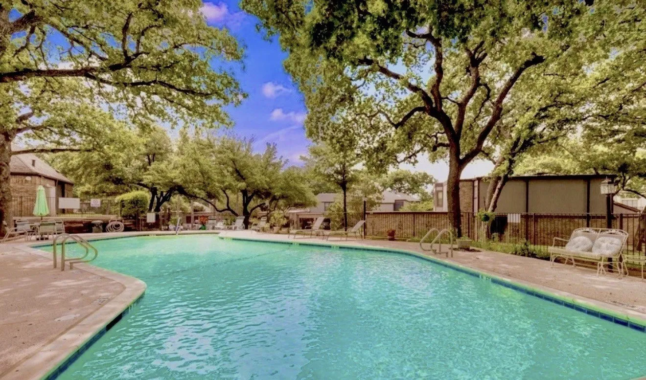 Clubhouse includes urved swimming pool with concrete decking, surrounded by mature trees.