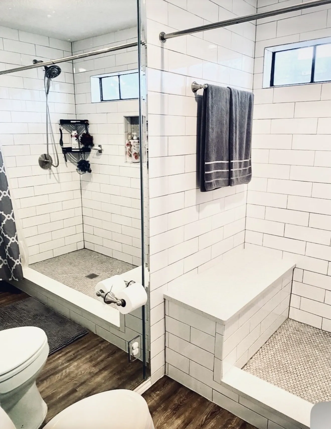 Walk-in shower with clear glass enclosure, subway tile walls, built-in niche, and a built-in shower bench