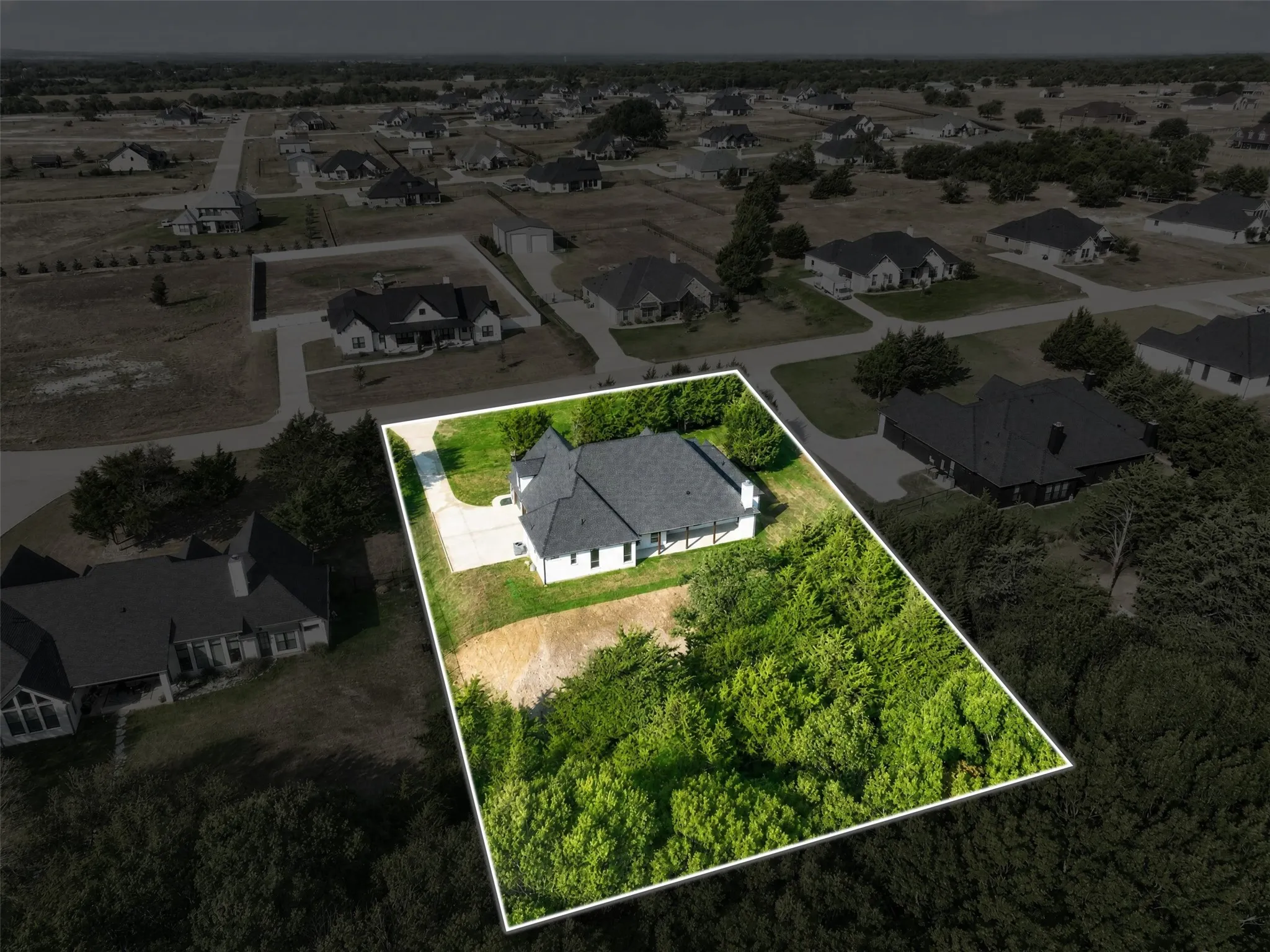 Aerial View highlights the property boundries, spacious homesite and mature trees, offering a clear perspective of the home's setting and surrounding neighborhood.