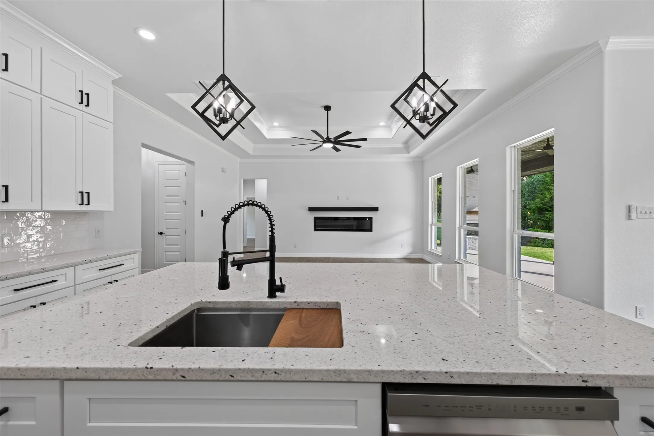 Oversized kitchen island offers generous prep space with an undermount sink and statement faucet, while overlooking the open living area.