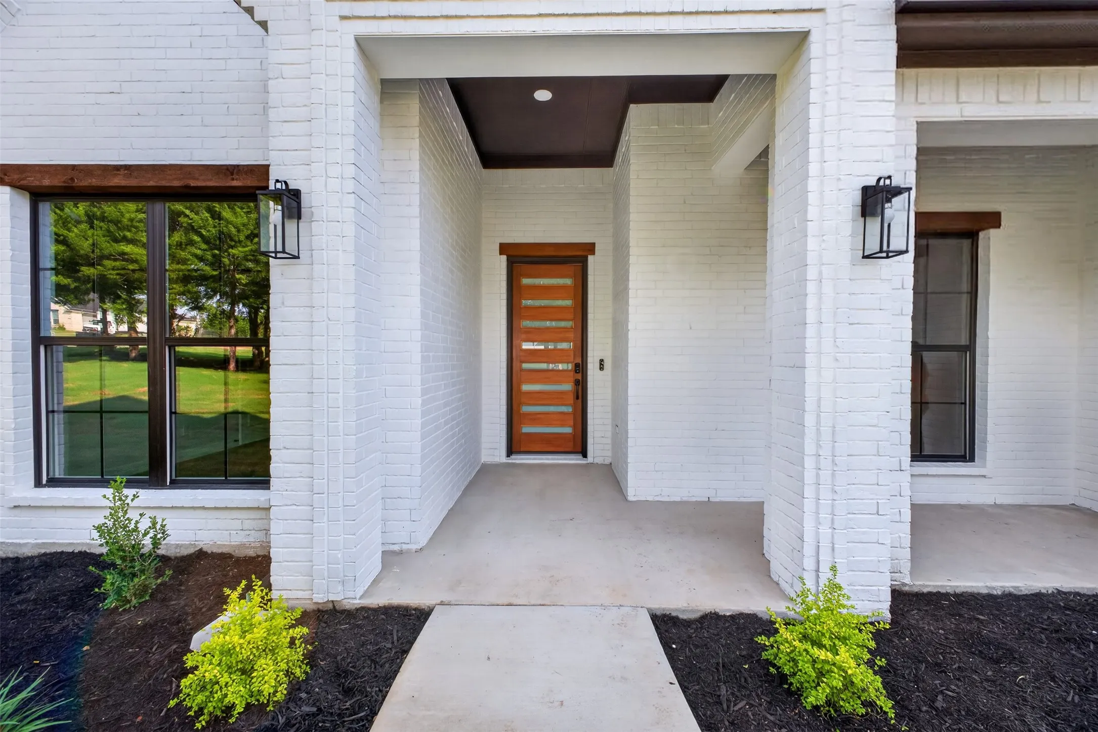 Welcoming covered front entry featuring a modern statement door and clean architectural details.