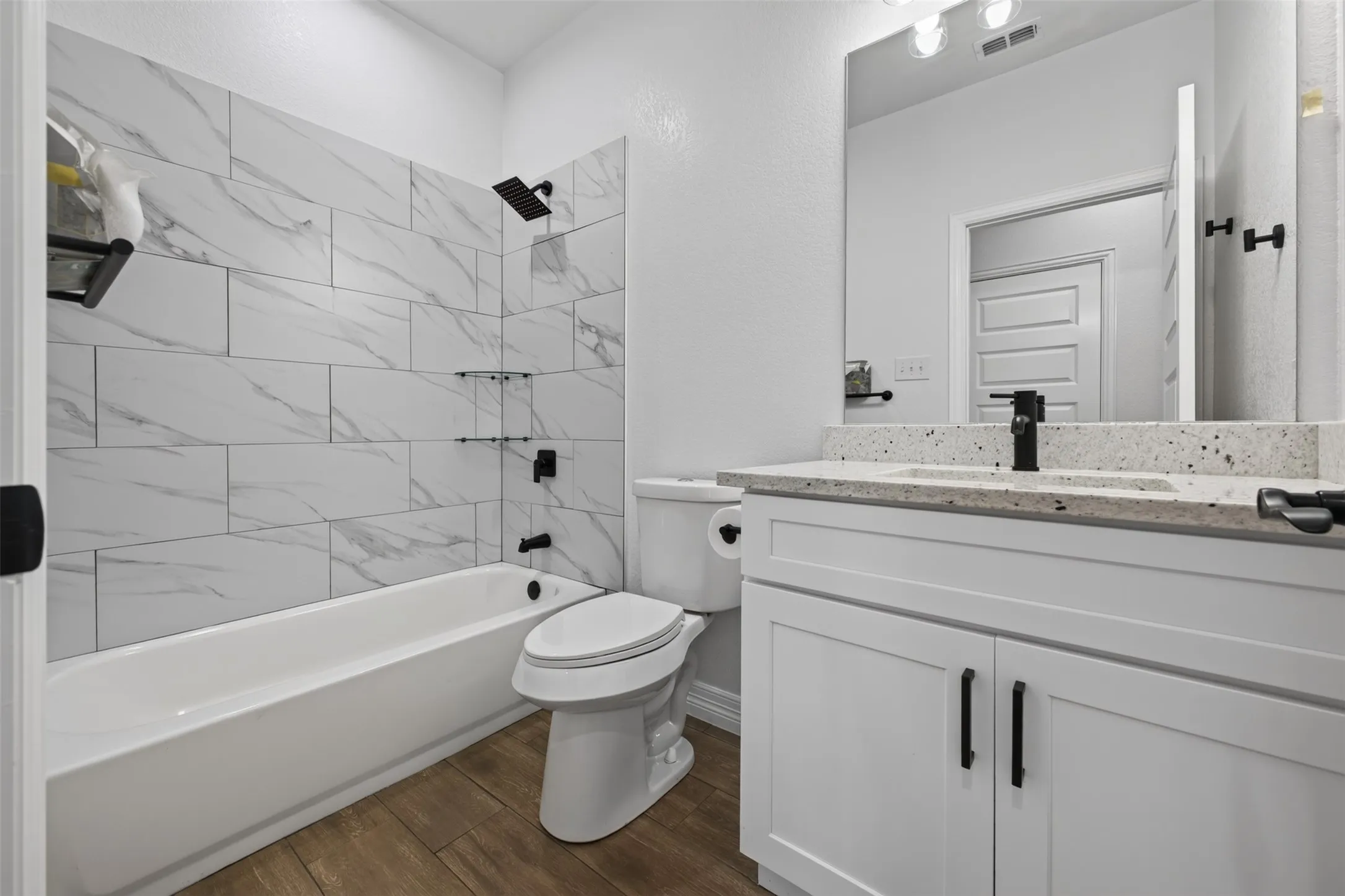 Guet bath featuring a tub/shower combination with stylish tile surround and modern finishes.