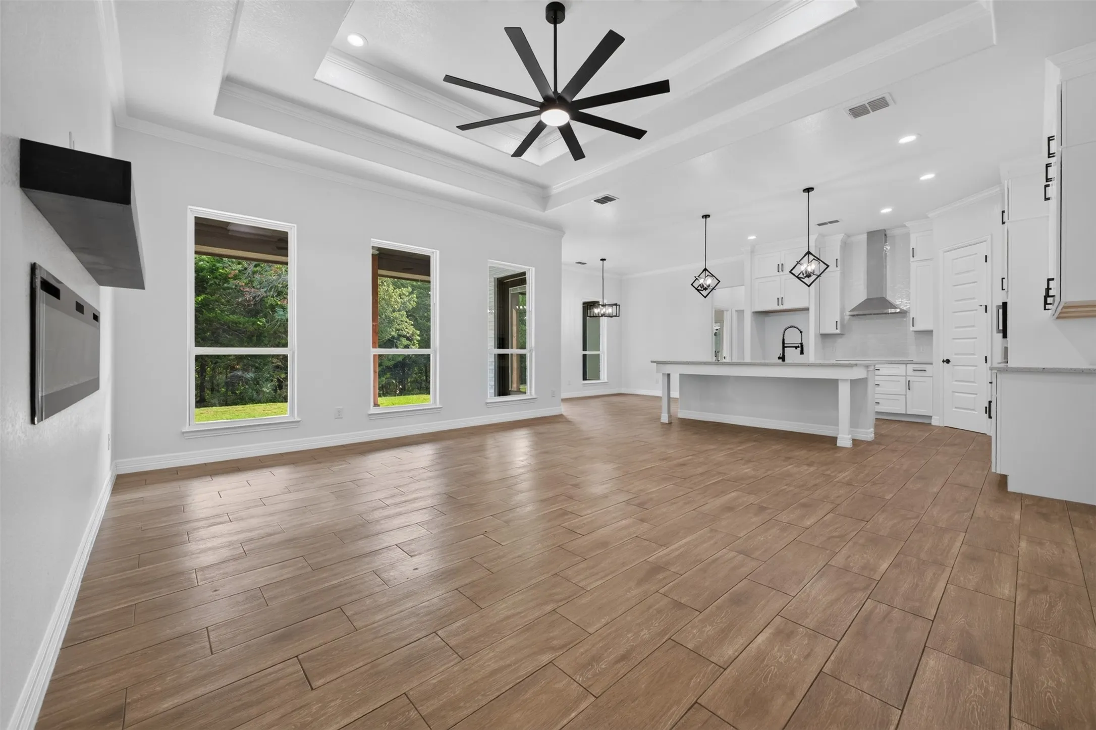 Light-filled living area with large windows, modern fireplace, and an open flow into kitchen-perfect for everyday living and entertaining.