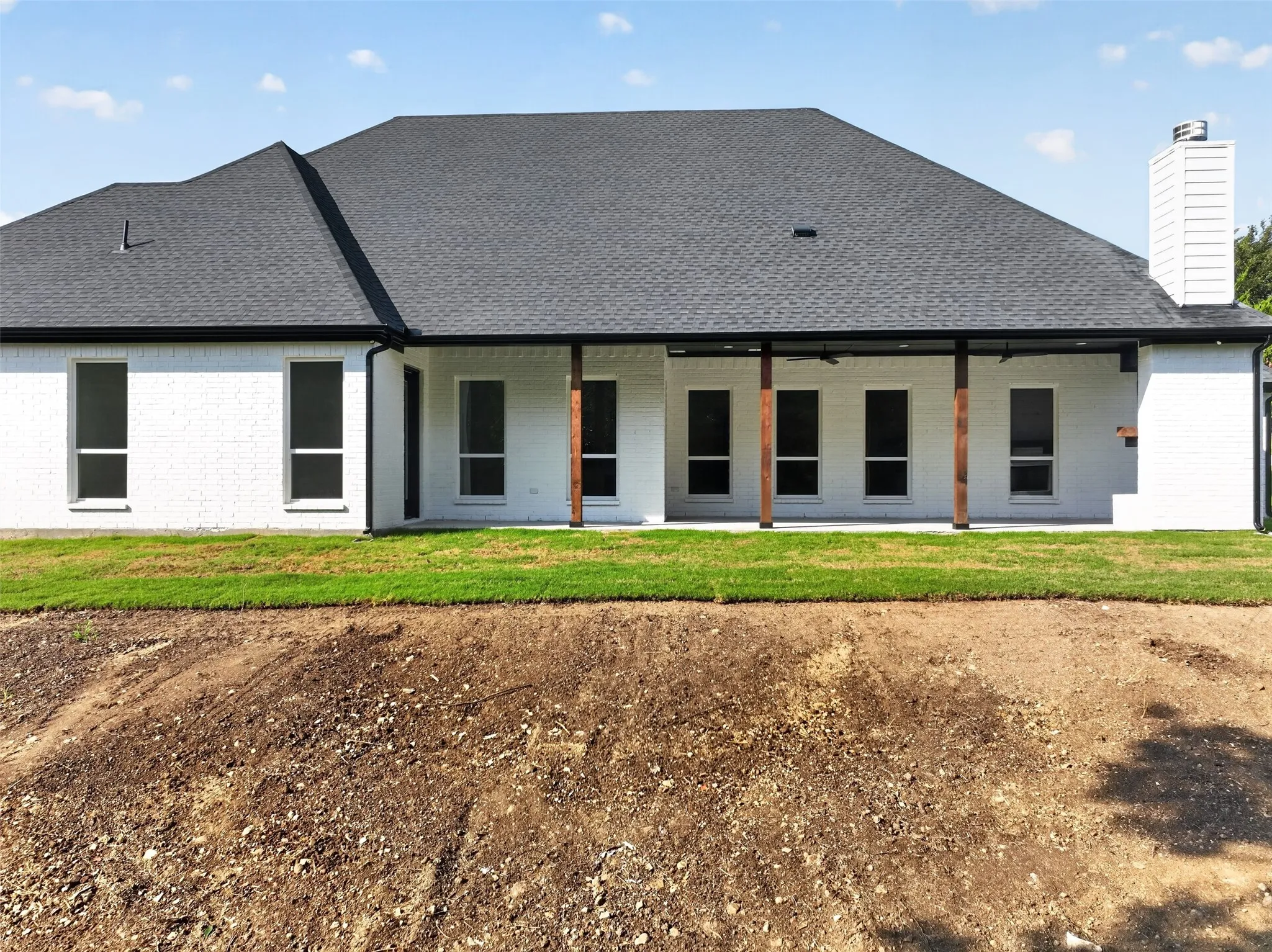 Rear exterior showcases an expansive covered patio overlooking the spacious backyard-ideal for outdoor living and entertaining.