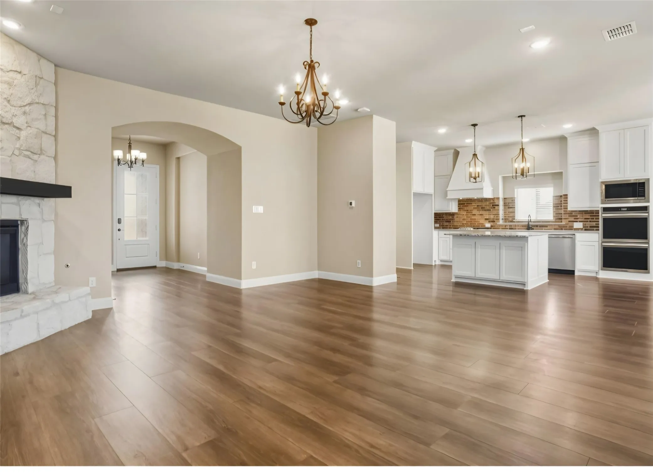 Expansive open-concept living space with wood-finish flooring