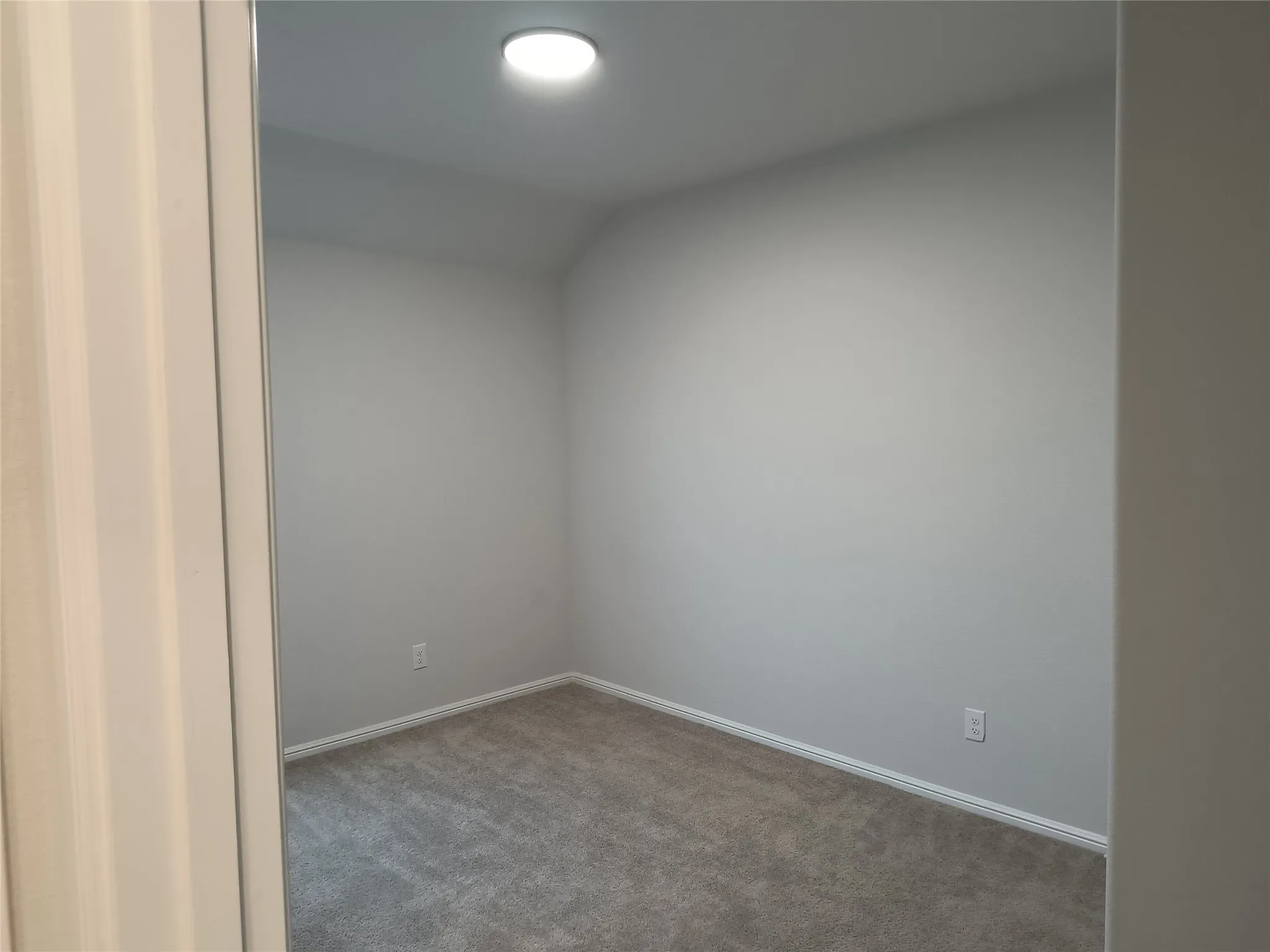 Carpeted interior space with a recessed ceiling light