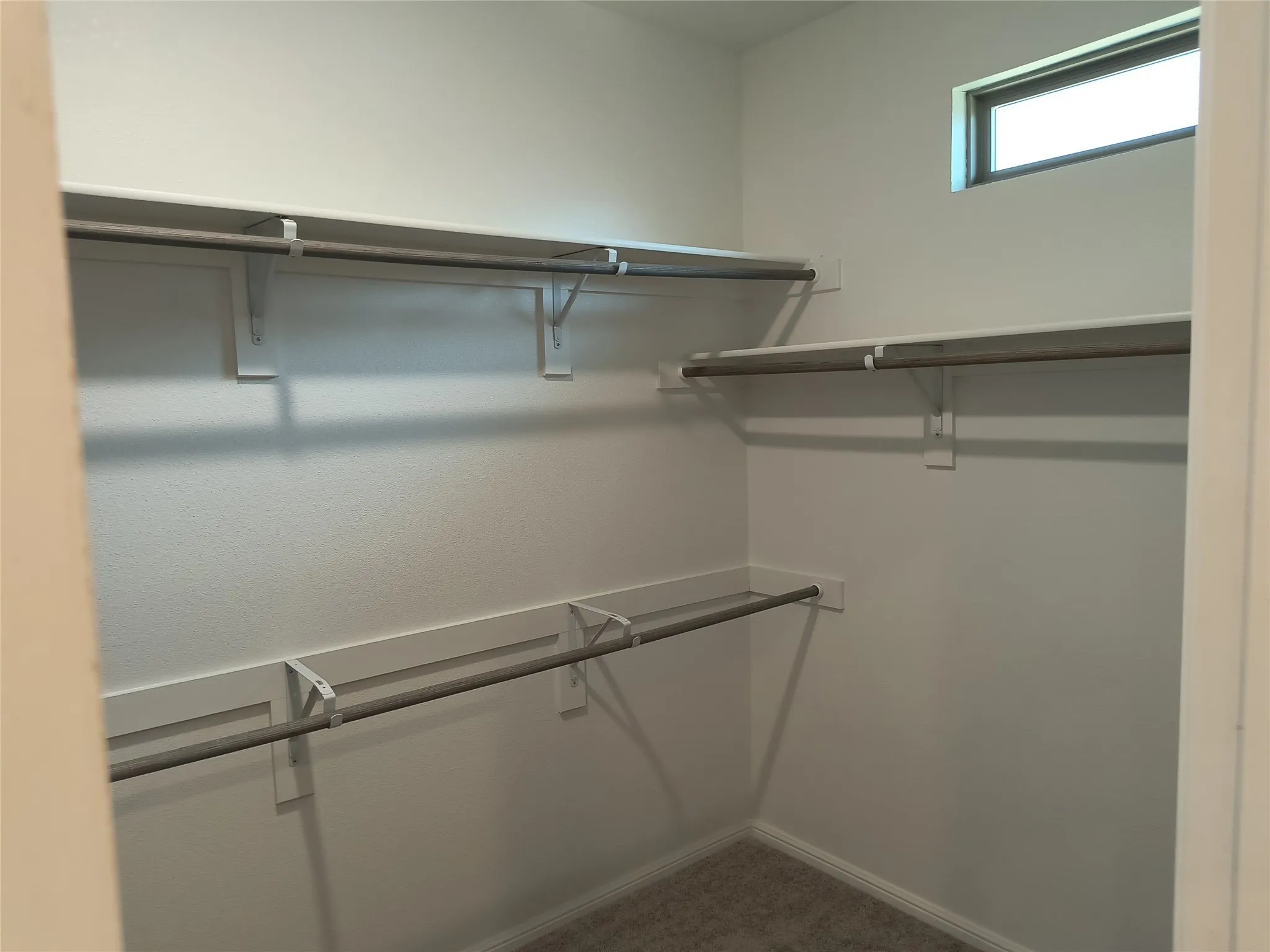 Built-in shelving and hanging rods, high-set window, carpet flooring