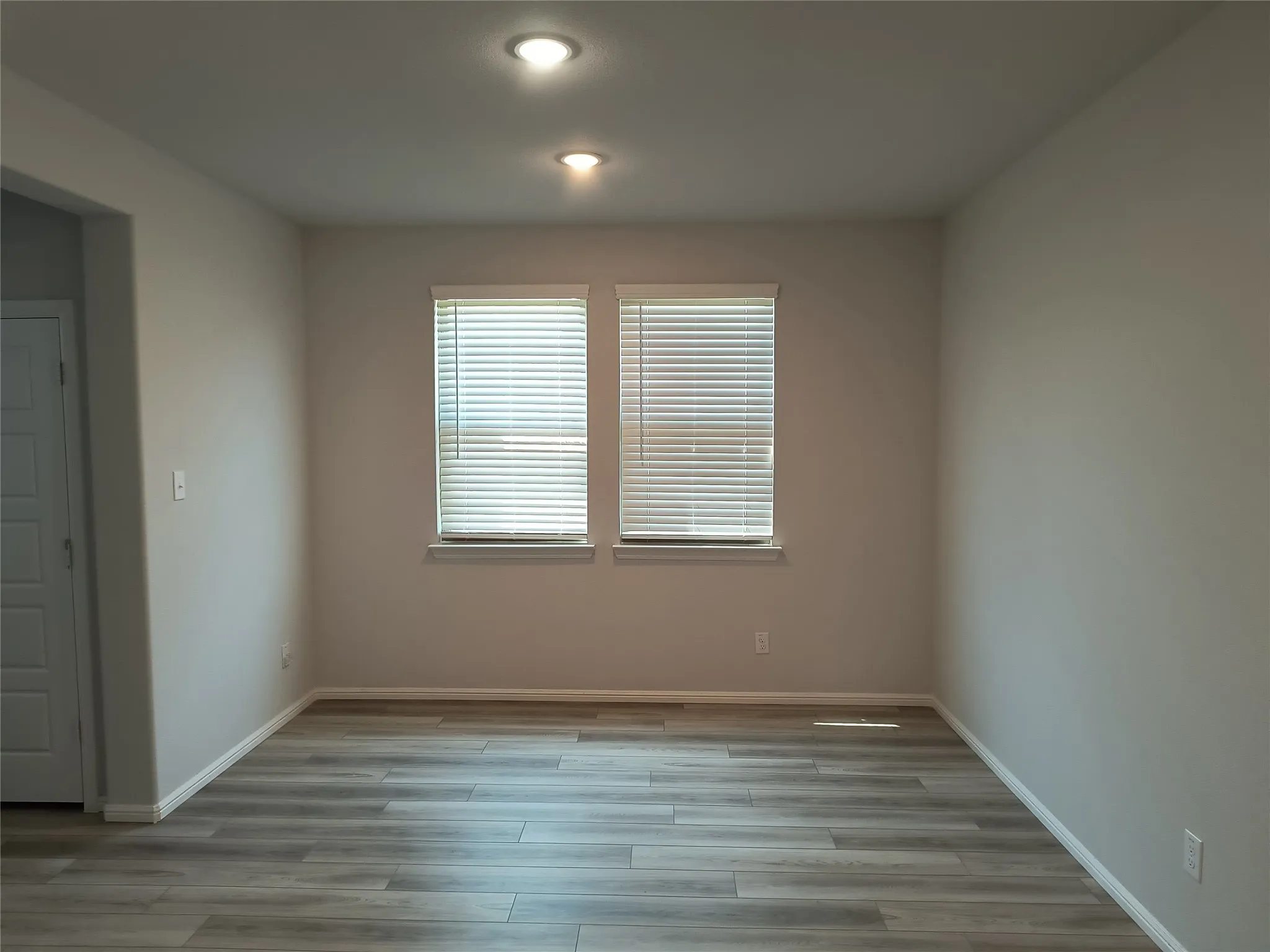 Neutral wall tones, recessed lighting, wood-finish flooring, and white window blinds
