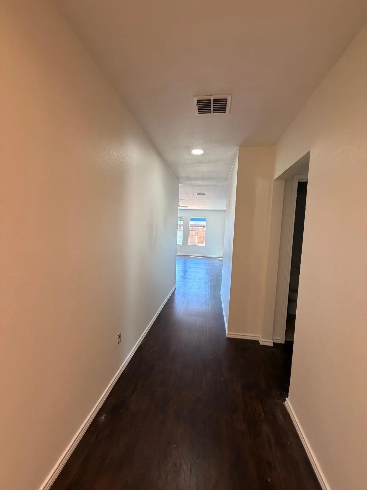 Hallway featuring wood-finish flooring, recessed lighting, and neutral wall paint