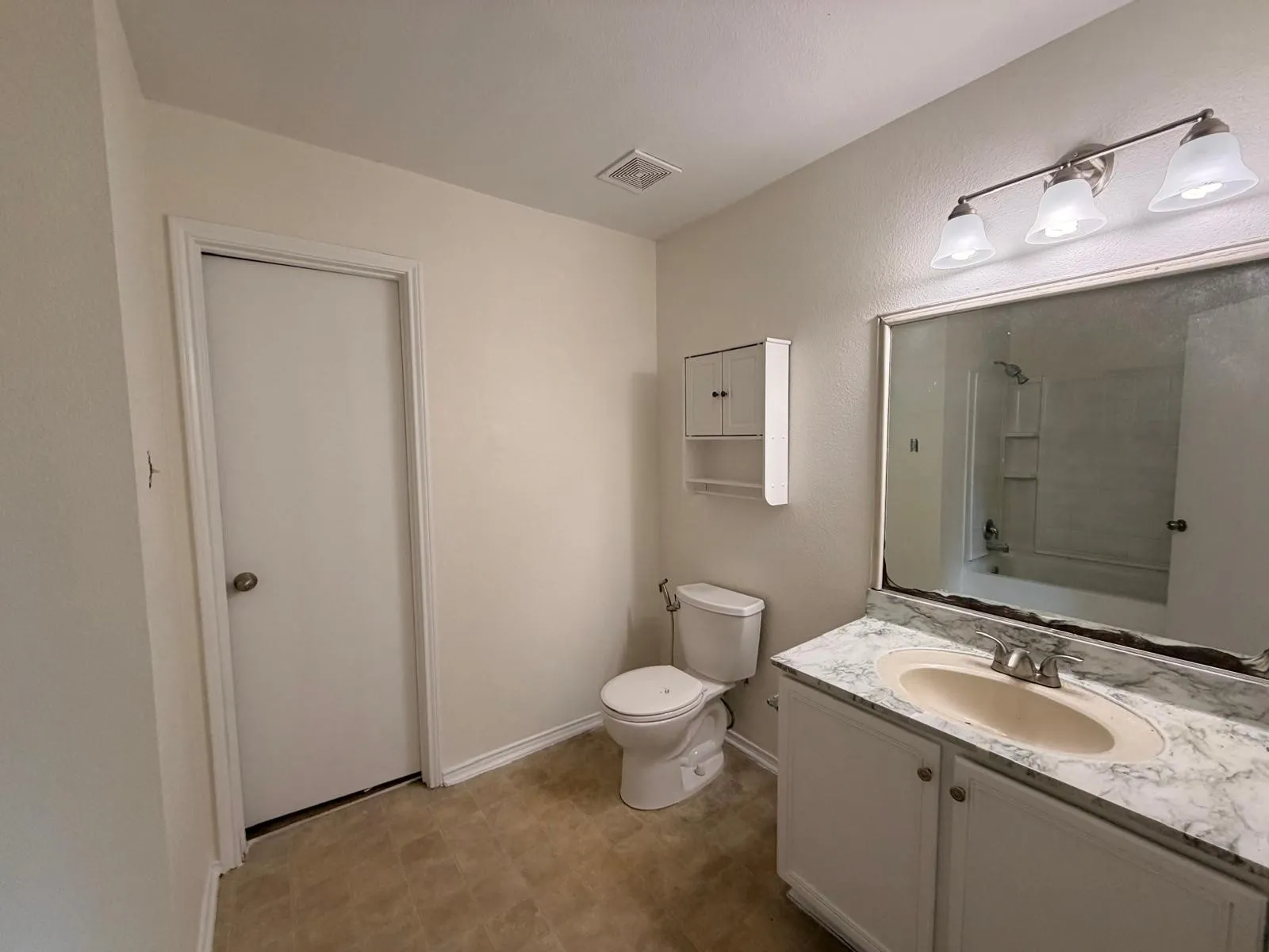 Bathroom featuring a single vanity with a laminate countertop, integrated sink, and an overhead three-light fixture